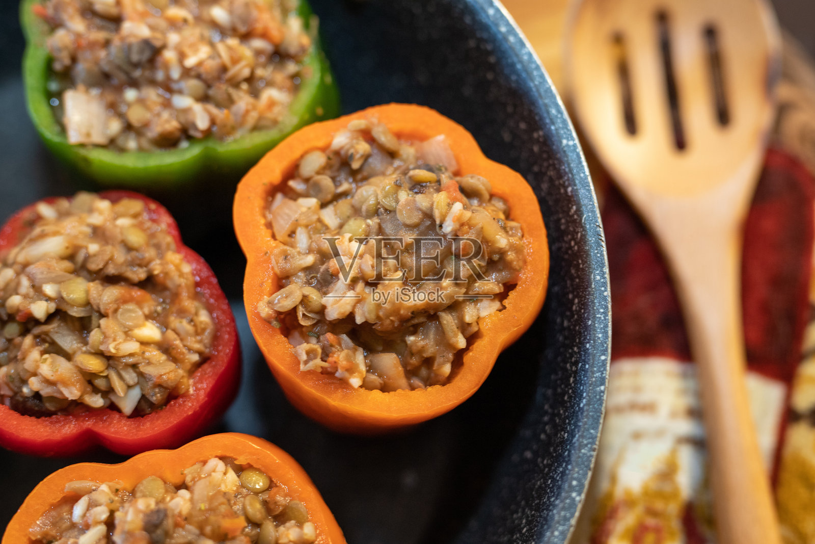 顶部视角的素食填充椒在汤锅中，背景有木制搅拌勺照片摄影图片