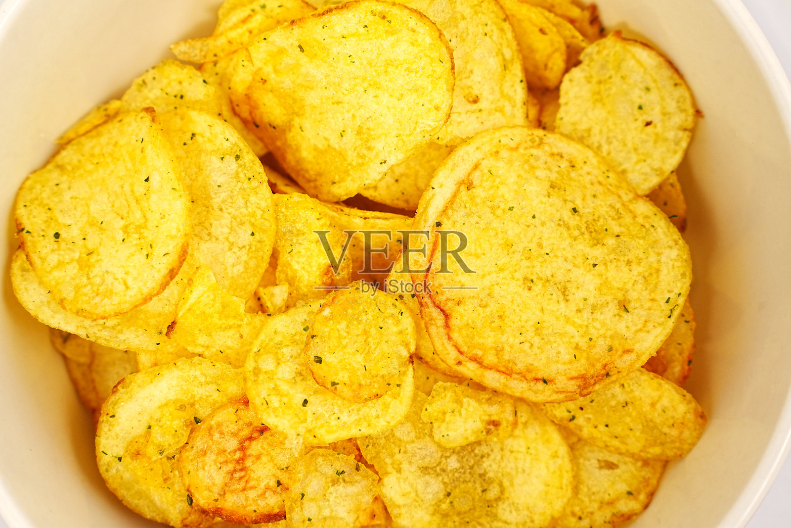 碗里装着带香料的薯片。照片摄影图片