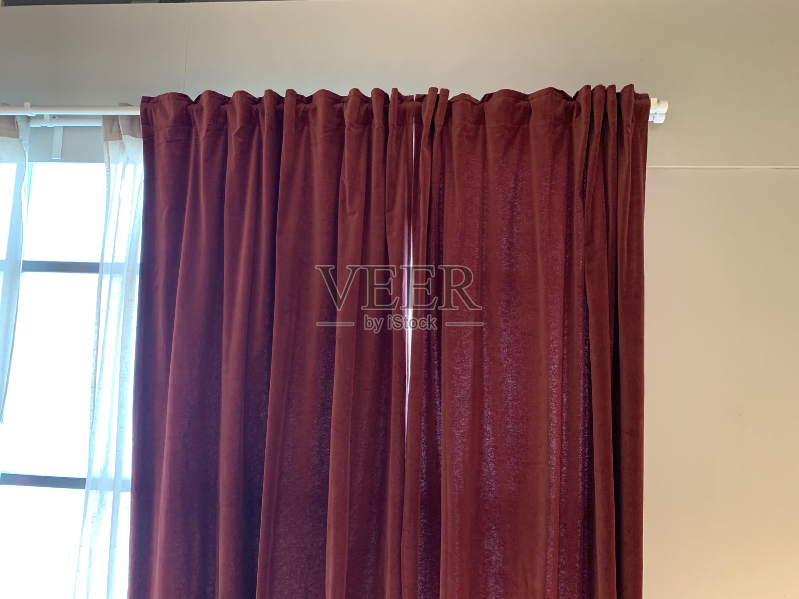 深红色遮光窗帘挂在窗杆上照片摄影图片
