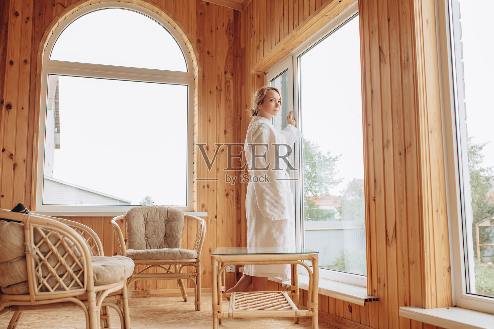 一位年轻女性穿着浴袍在阳台上享受早晨时光照片摄影图片