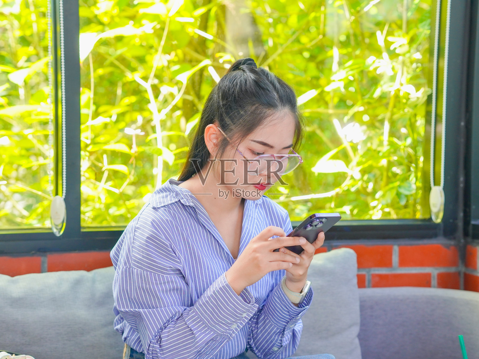 亚洲女商人在远程工作，使用笔记本电脑、手机和笔记本写笔记并规划小型企业的路线图。照片摄影图片