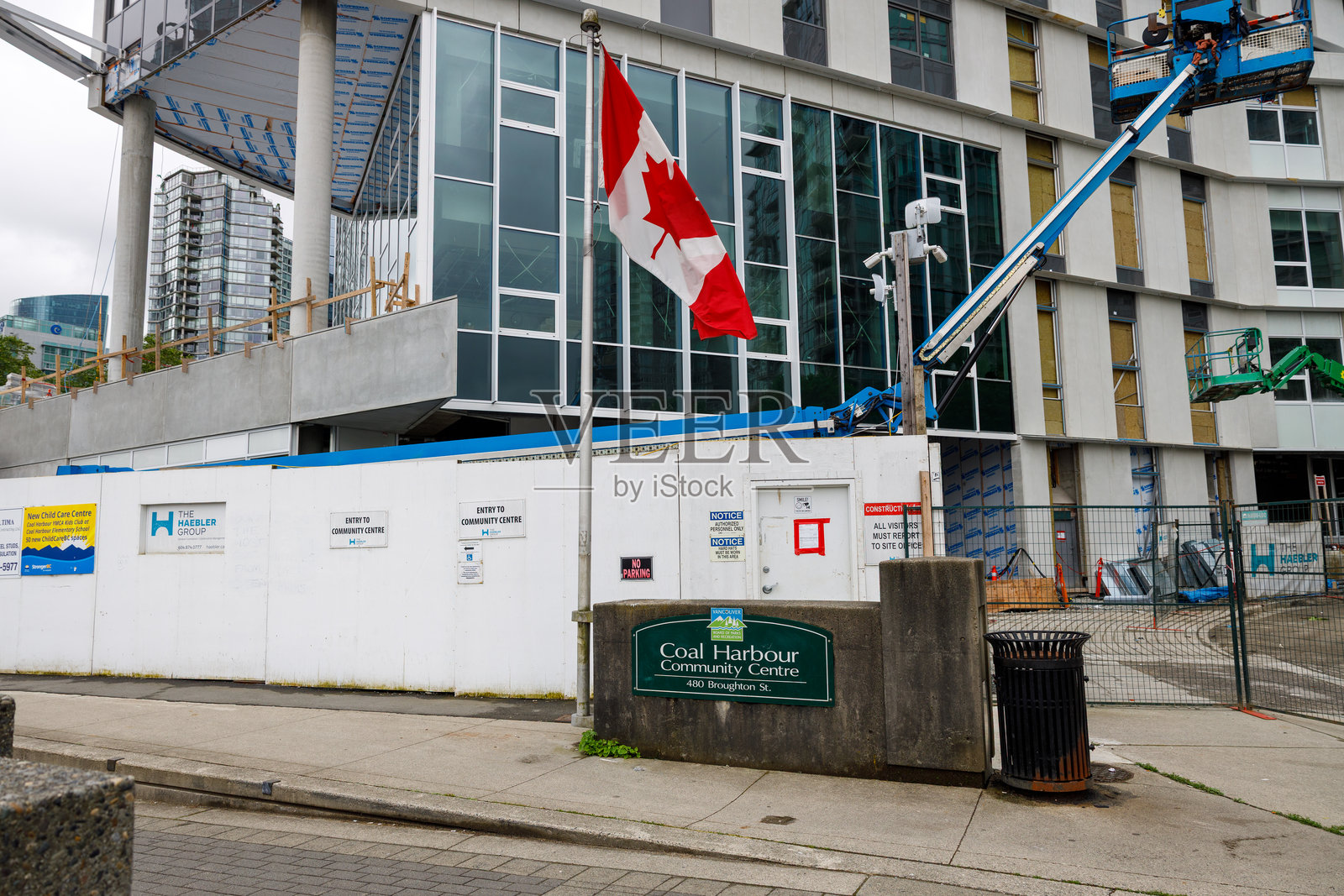 新煤港小学的施工现场，展示了一座现代化的玻璃外立面建筑、起重机和覆盖的材料。照片摄影图片