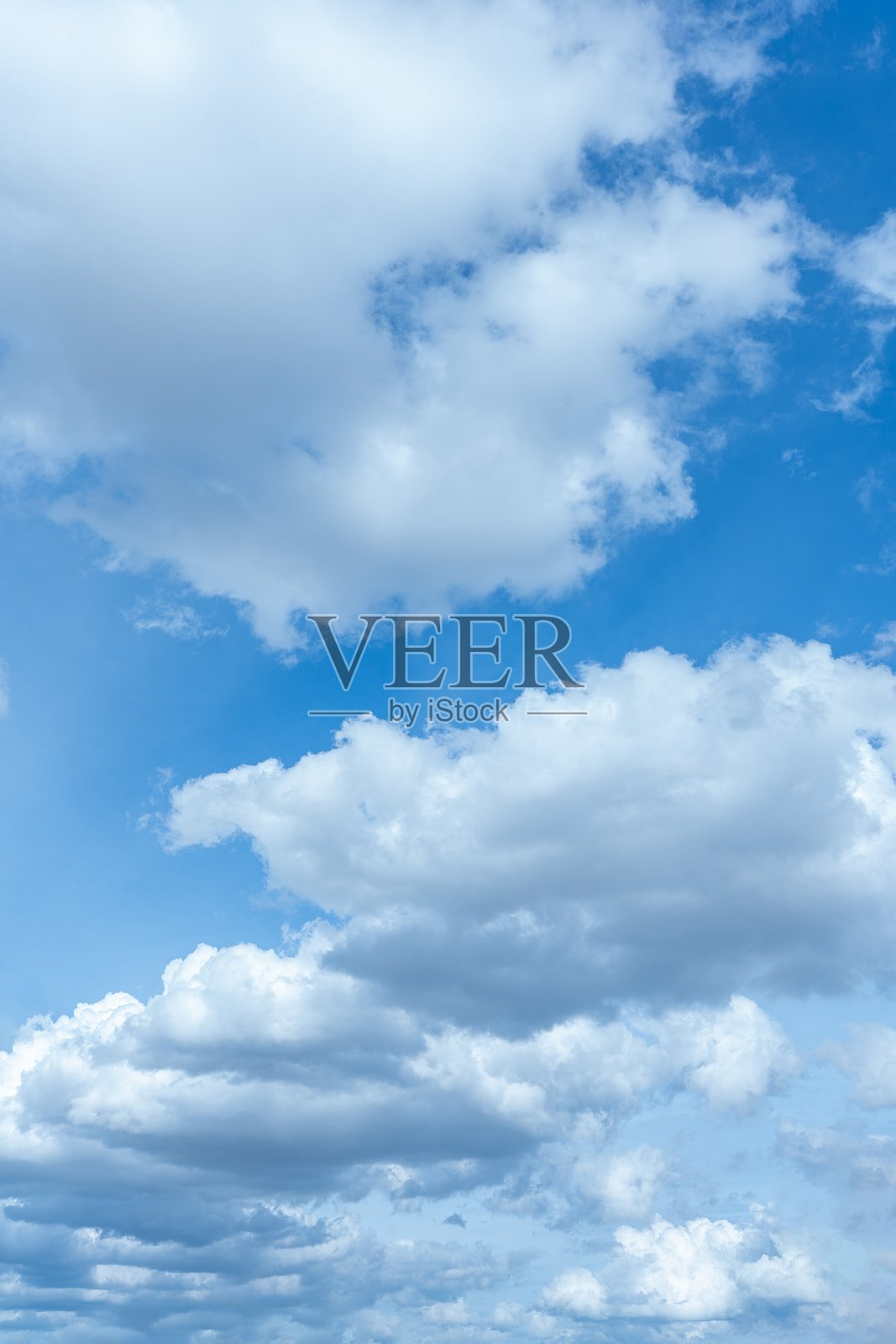 晴朗的日子里，明亮的蓝天上布满了蓬松的白色和浅灰色的积云。照片摄影图片