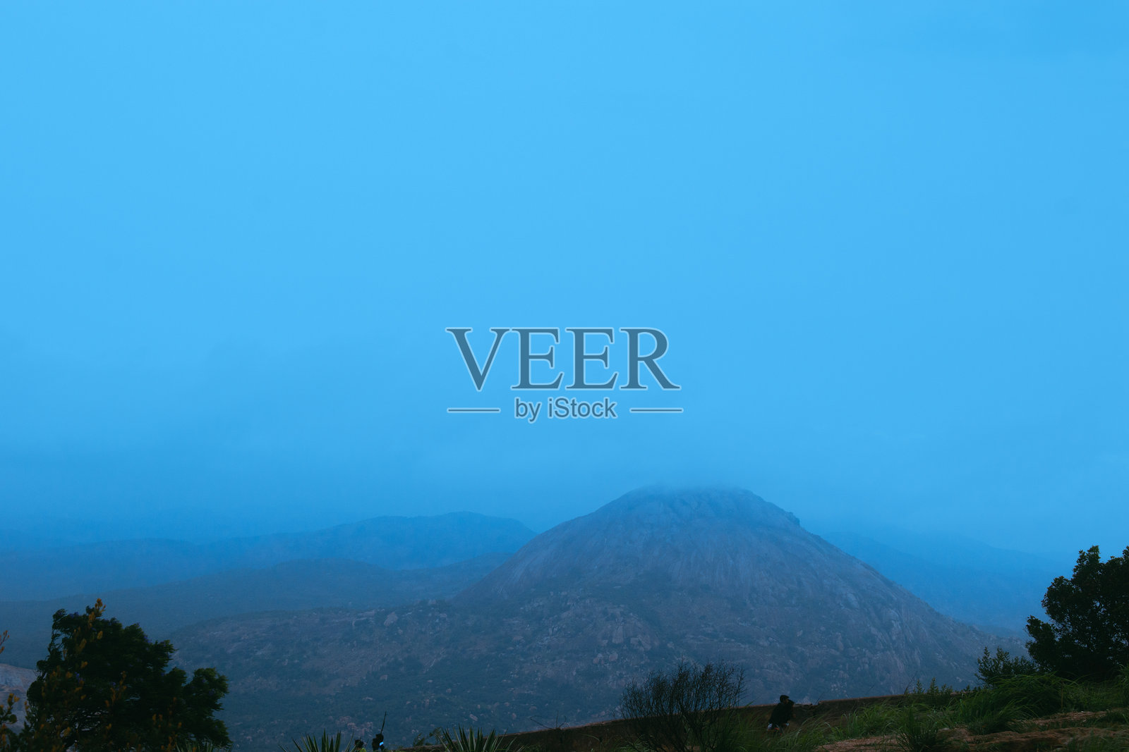 宁静的南迪山风景在黎明时分，展现出薄雾笼罩的山脉和淡蓝色的天空。照片摄影图片