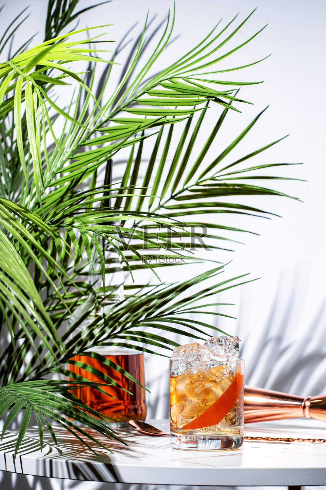 色彩斑斓的鸡尾酒创作，包含伏特加、阿夸维特、意大利开胃酒和苏格兰威士忌，搭配葡萄柚风味，摆放在时尚的桌子上照片摄影图片