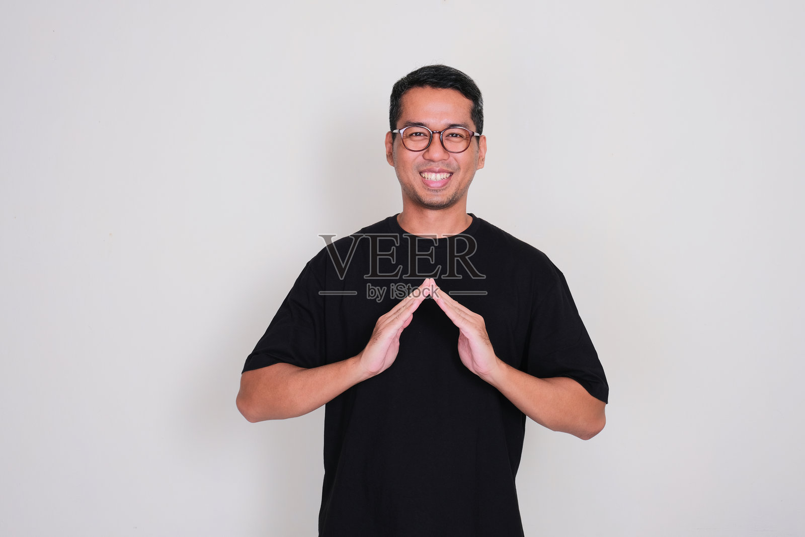 微笑的亚洲成年男子用手做出房子的形状照片摄影图片