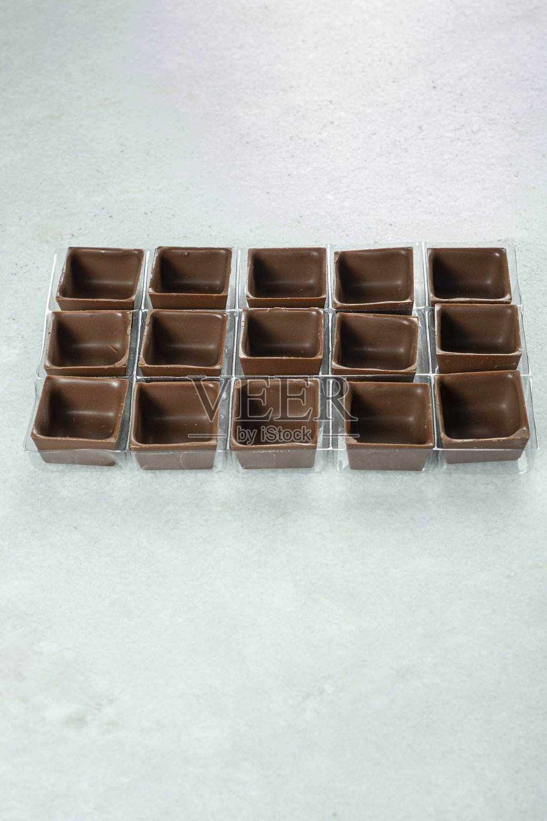方形牛奶巧克力外壳在模具内_顶部视图_垂直。照片摄影图片