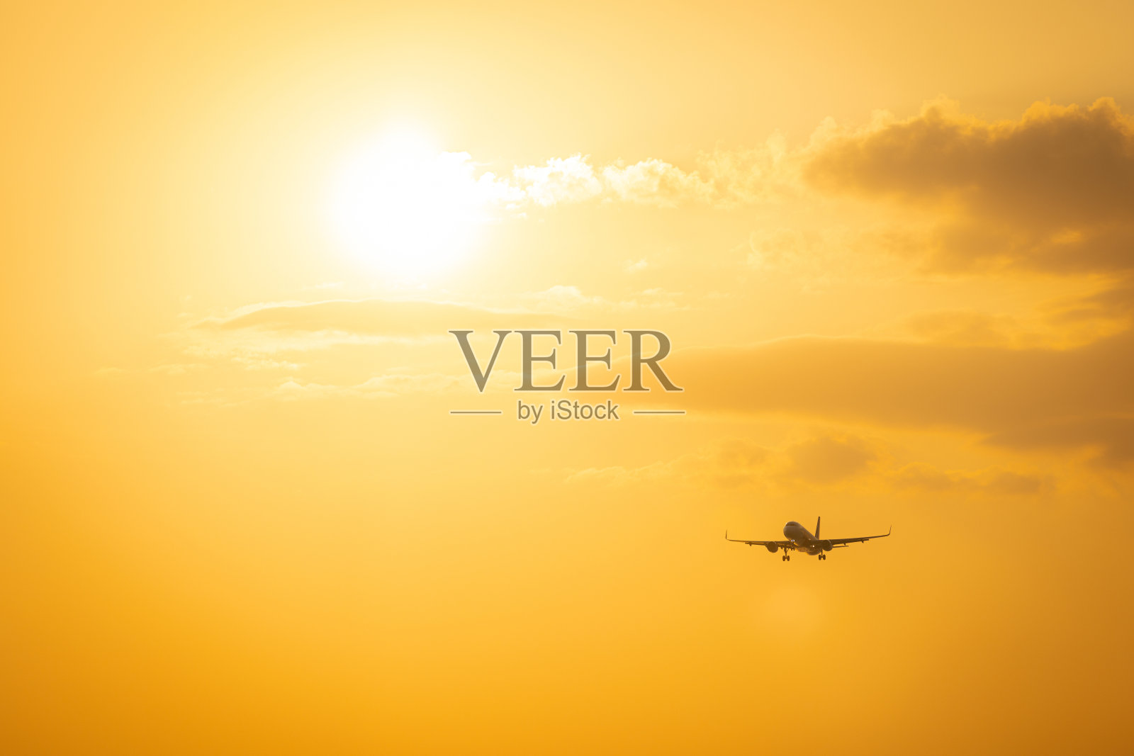 飞机在日落的天空中飞行。照片摄影图片