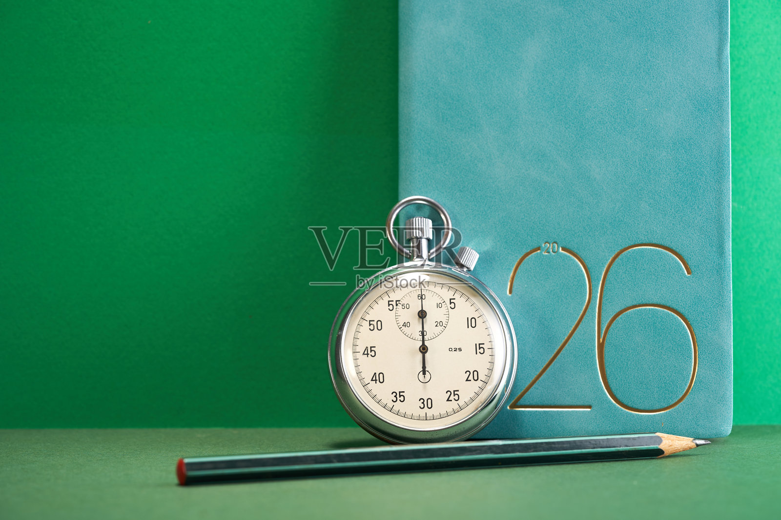 2026年计划本、秒表和铅笔，背景为绿色照片摄影图片