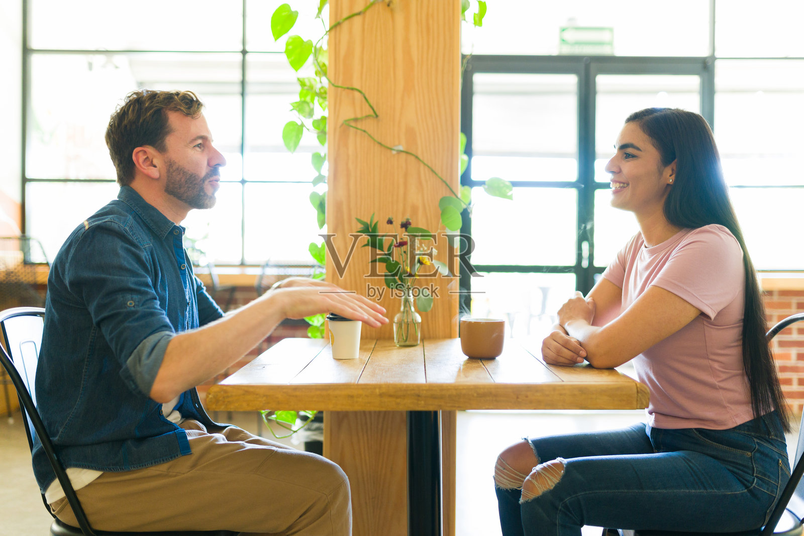 情侣在温馨的咖啡馆享受咖啡和交谈照片摄影图片