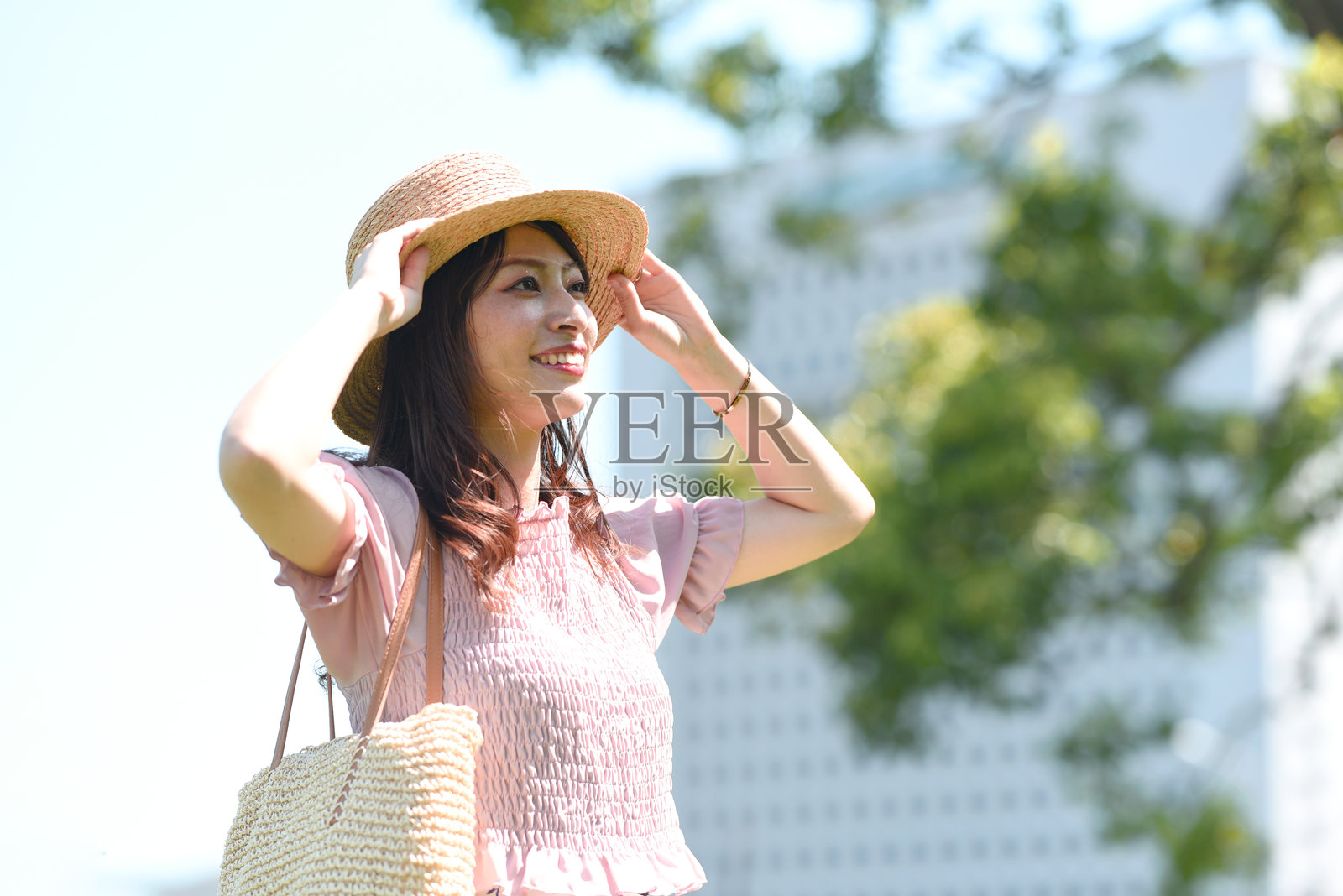 年轻微笑的亚洲女性戴着草帽照片摄影图片