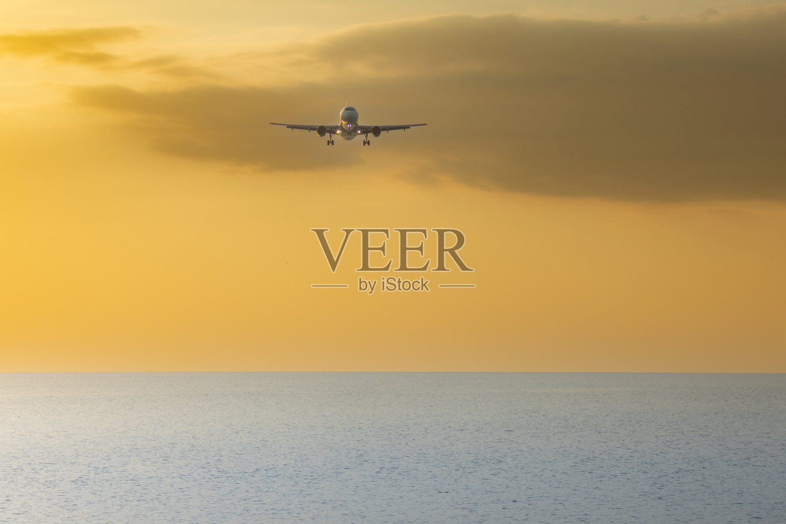 飞机在日落的天空中飞行。照片摄影图片