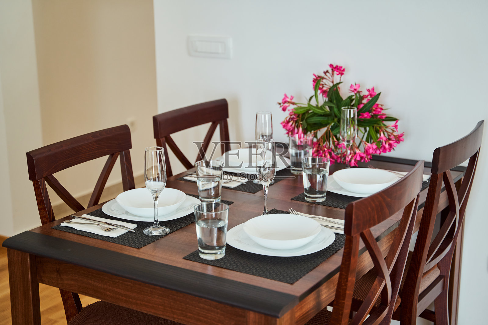 优雅的餐桌布置，中央有花卉装饰和香槟杯，放在木桌上照片摄影图片