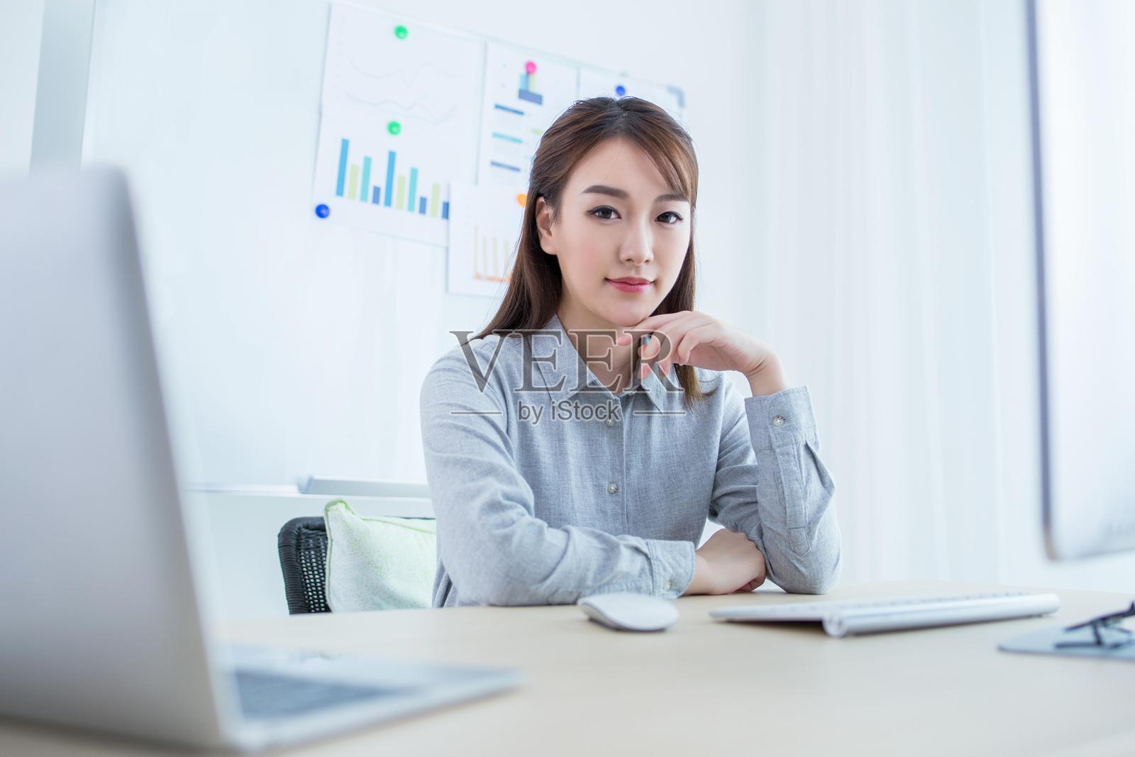 自信工作的亚洲女性在桌子前照片摄影图片