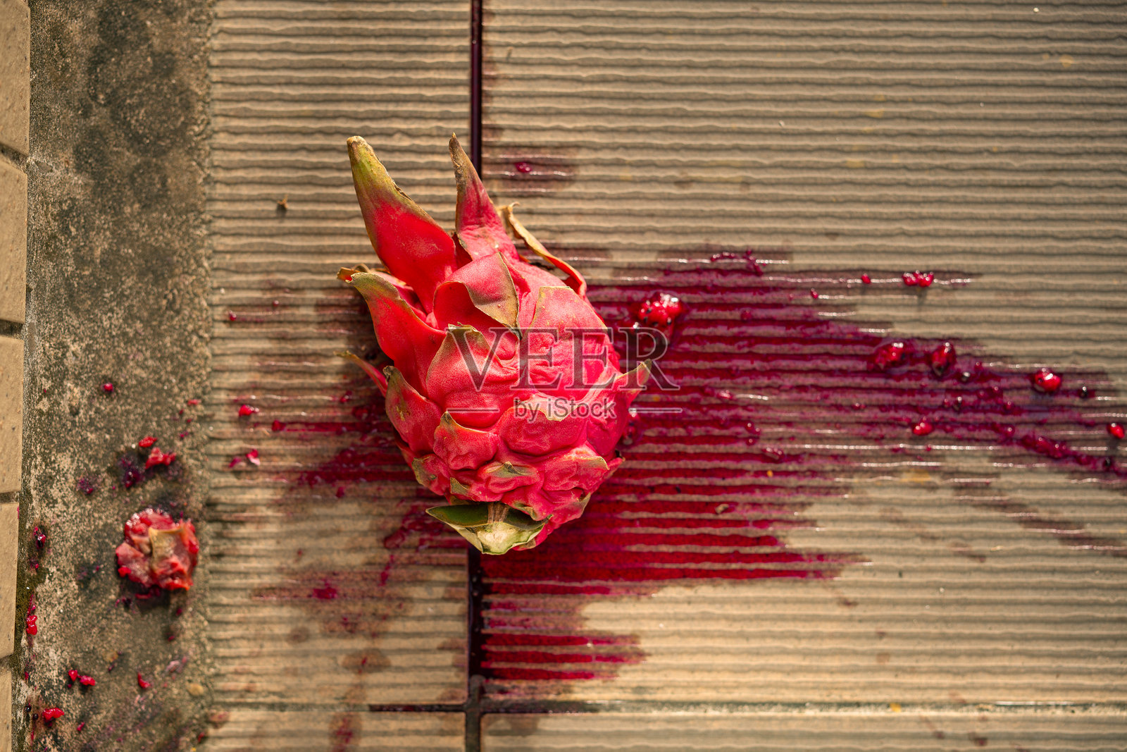 从上方看被压扁的红肉火龙果放在地上照片摄影图片