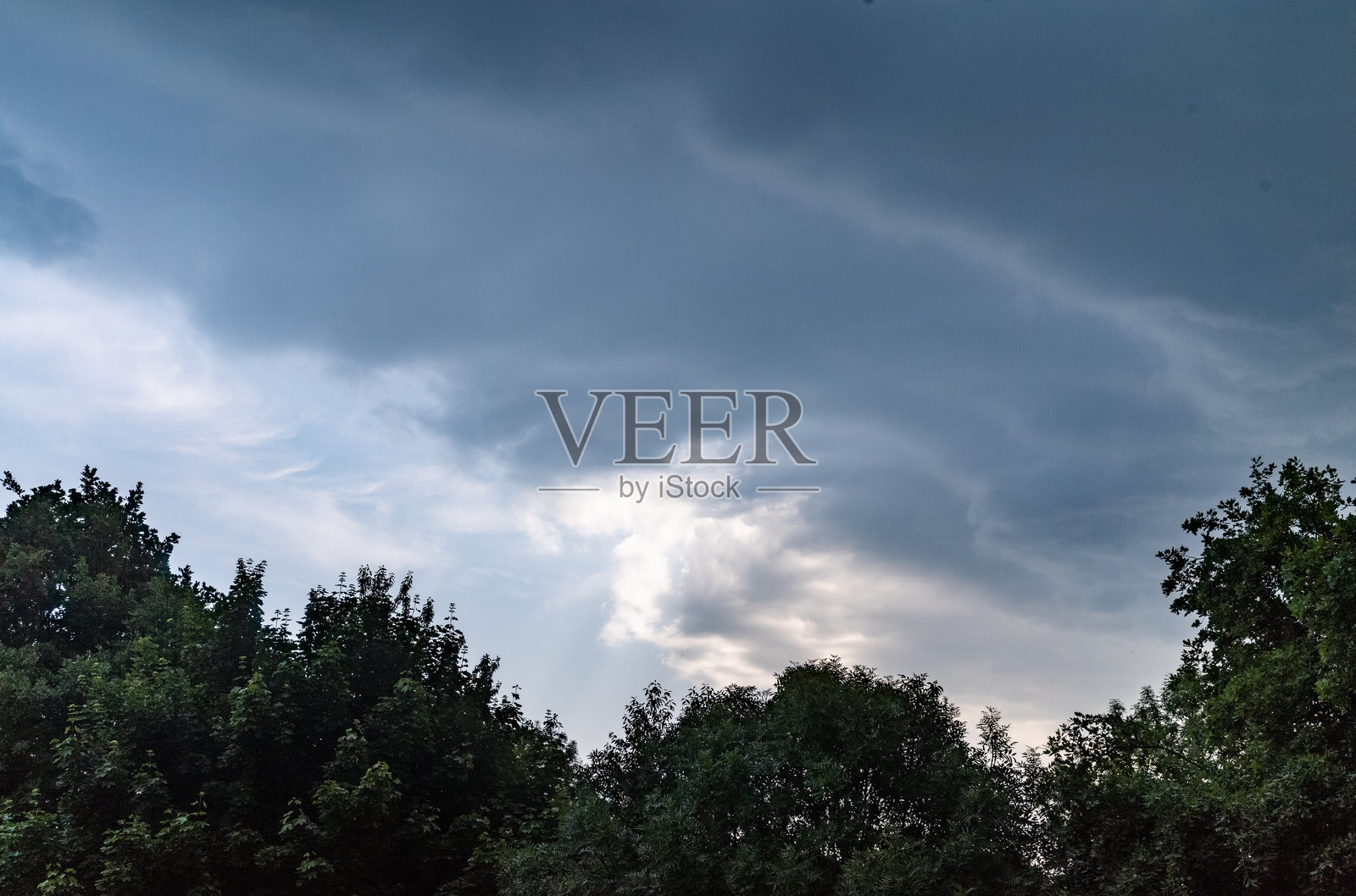 暴风云在树木前方掠过。德国北莱茵-威斯特法伦州照片摄影图片
