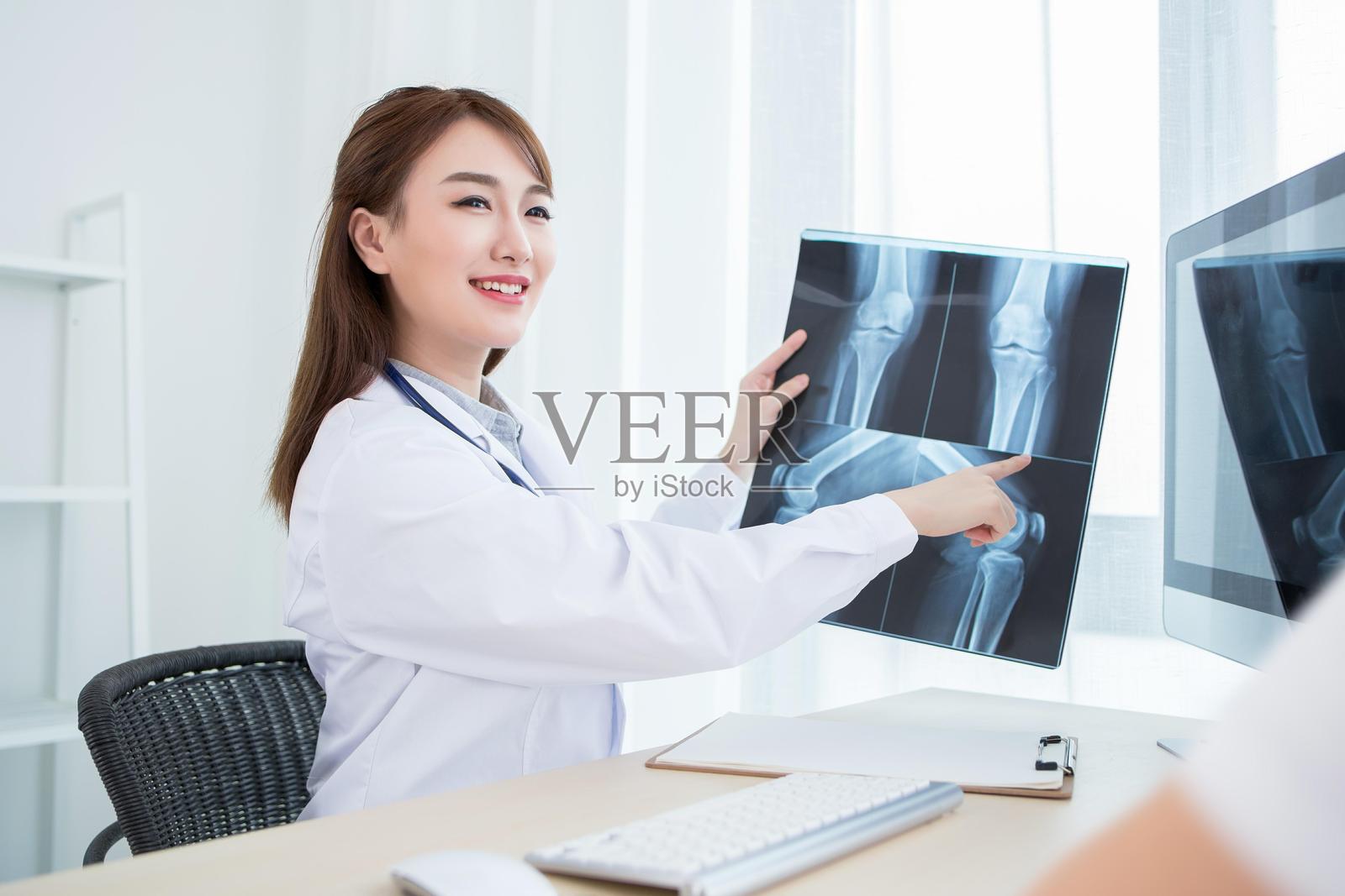 女医生在医疗办公室检查X光图像照片摄影图片