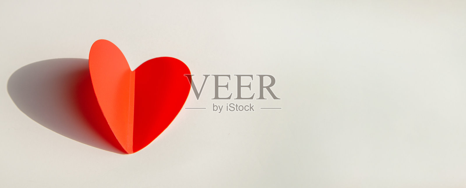 白色背景上有红色心形纸饰的横幅。平面图，俯视图，右侧留有文本空间。照片摄影图片