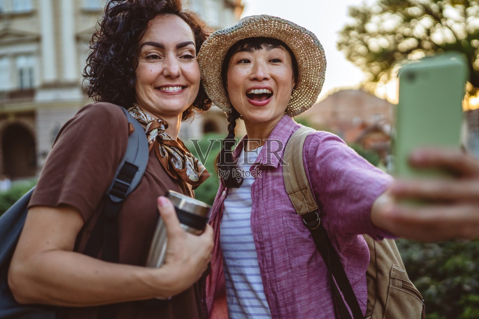 两位女性在度假时拍摄自拍，漫步游览城市。照片摄影图片