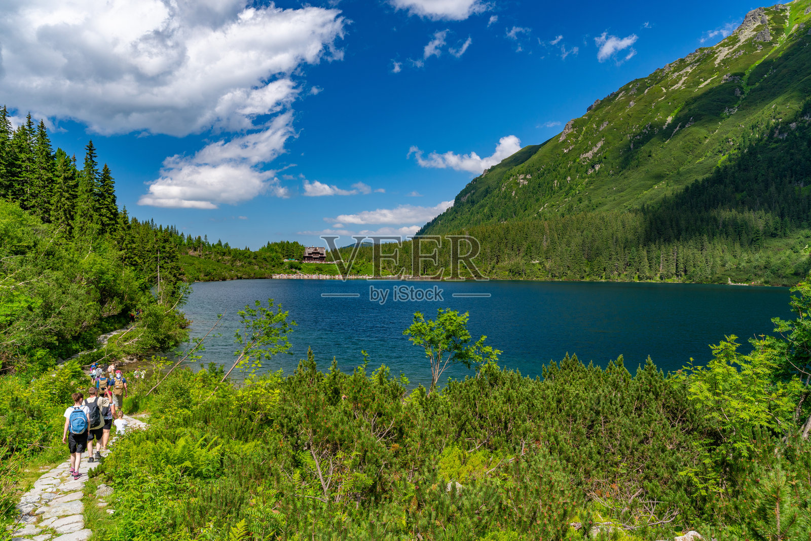 人们在波兰扎科帕内的塔特拉山脉中环绕摩尔斯基湖徒步旅行，摩尔斯基湖是该地区最大的湖泊。照片摄影图片