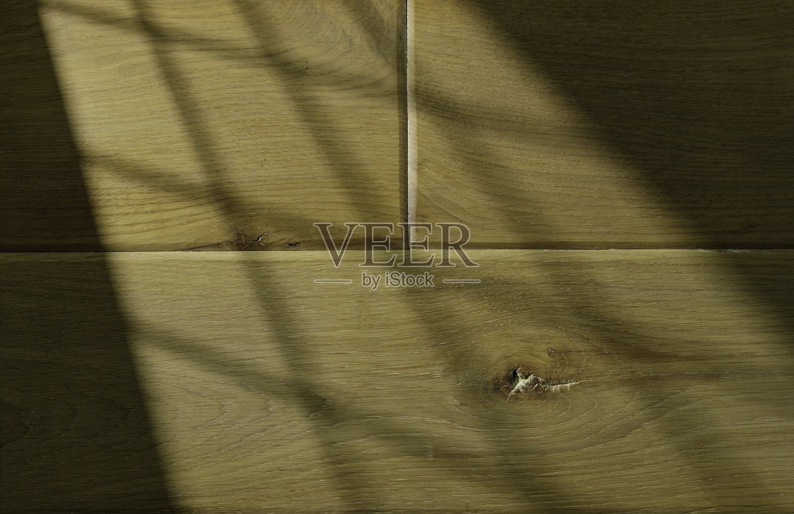 温暖灯光下带有自然纹理和微妙阴影的木质表面照片摄影图片