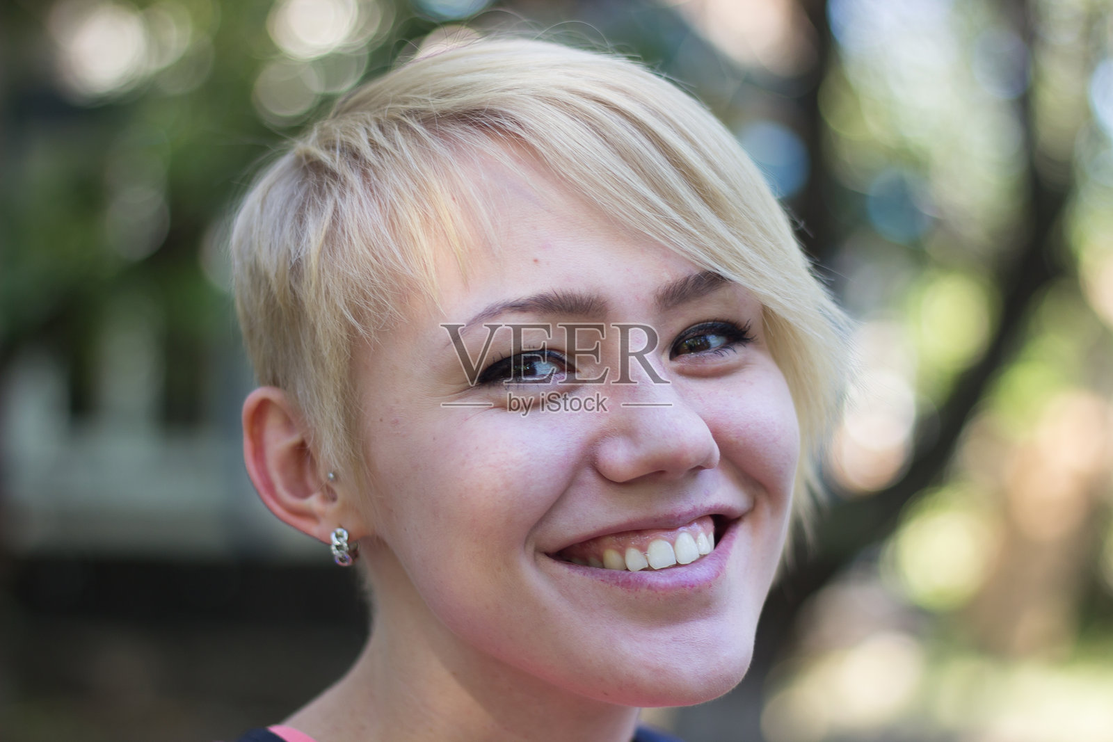 微笑的短发女孩在公园里享受阳光明媚的日子照片摄影图片