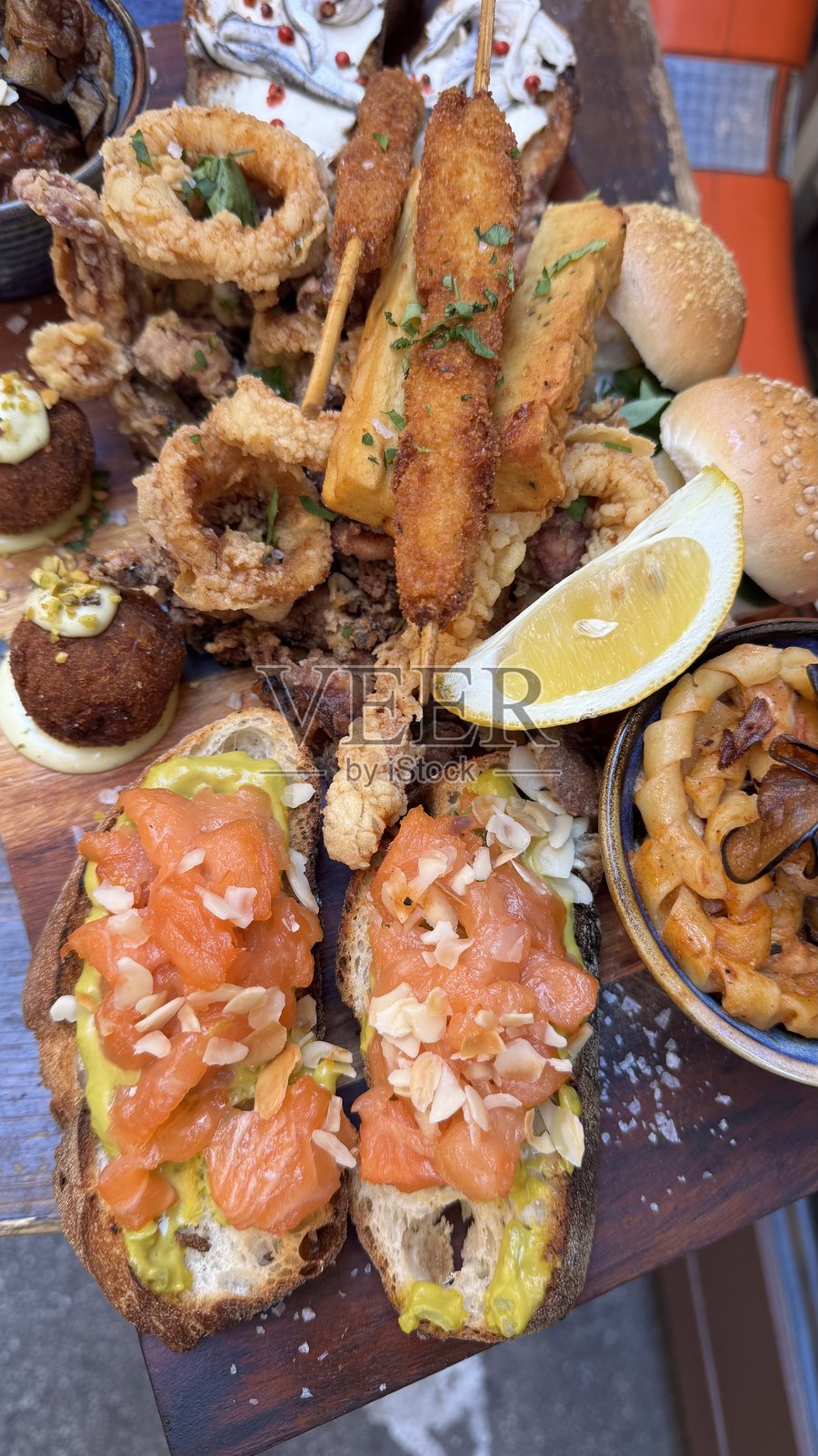 意大利海鲜美食。烤三文鱼和虾配蔬菜、柠檬和面包。意大利餐桌上的美食，随时可以享用。特写。照片摄影图片