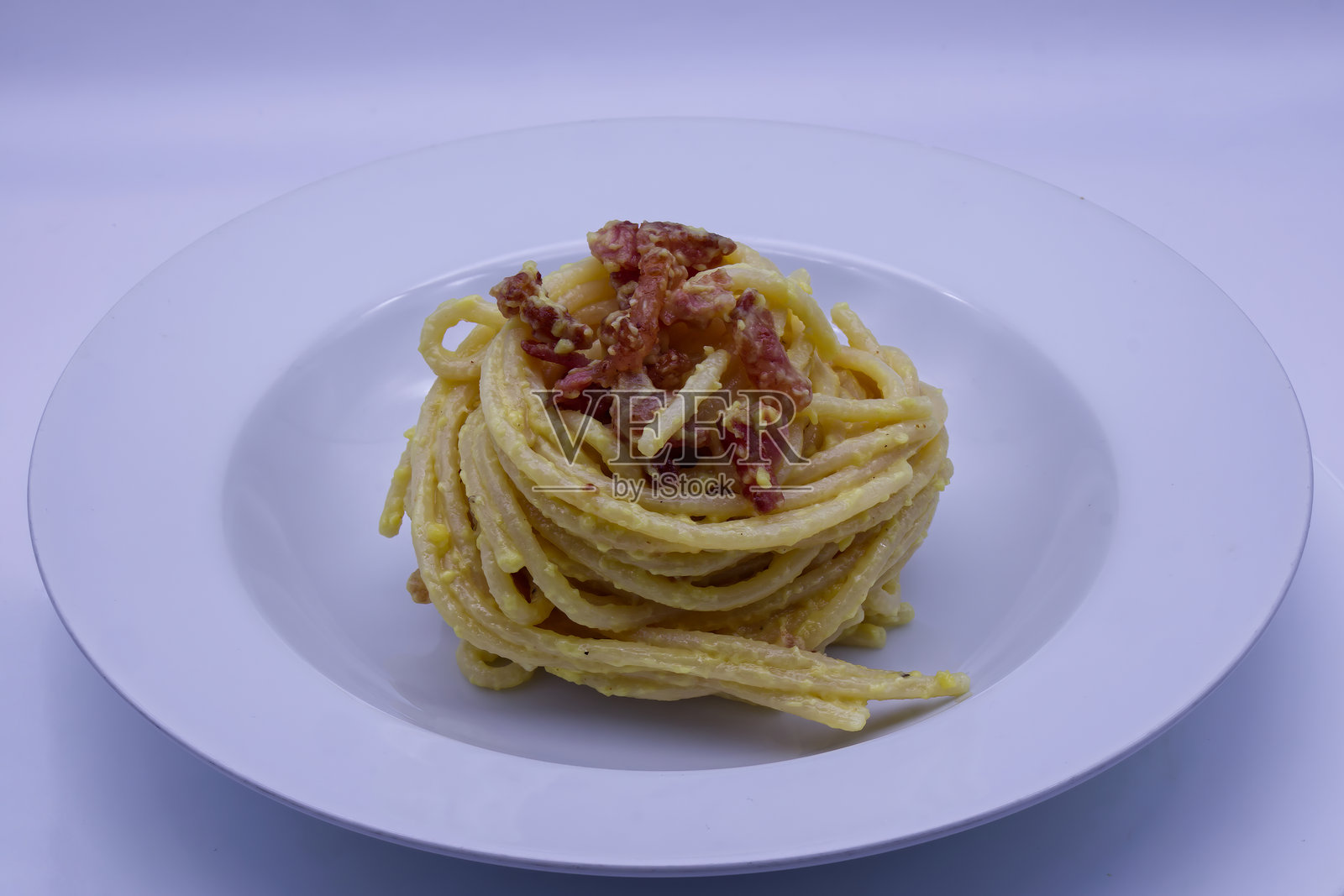 奶油意大利传统卡邦尼意面，配脆培根和佩科里诺罗马诺奶酪，胡椒粒，盛放在白色盘子上。照片摄影图片