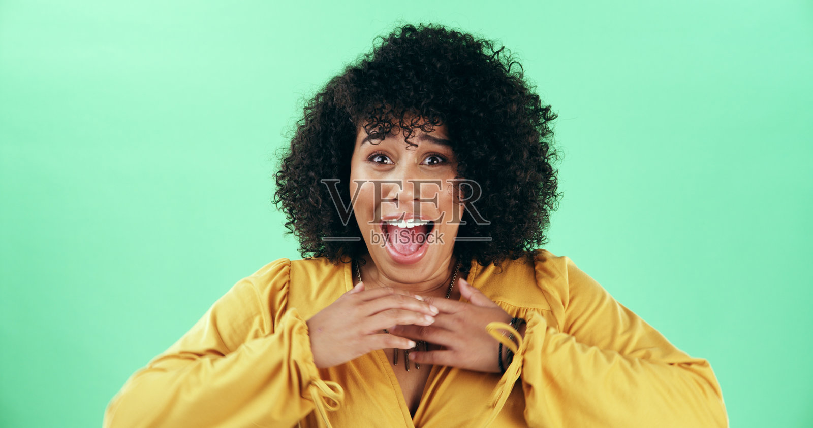 兴奋、惊讶的女性肖像，站在工作室里，手持中奖的彩票、奖品或促销信息。开心的销售人员在绿色背景前，面带惊叹、哇、天哪或震惊的表情。照片摄影图片