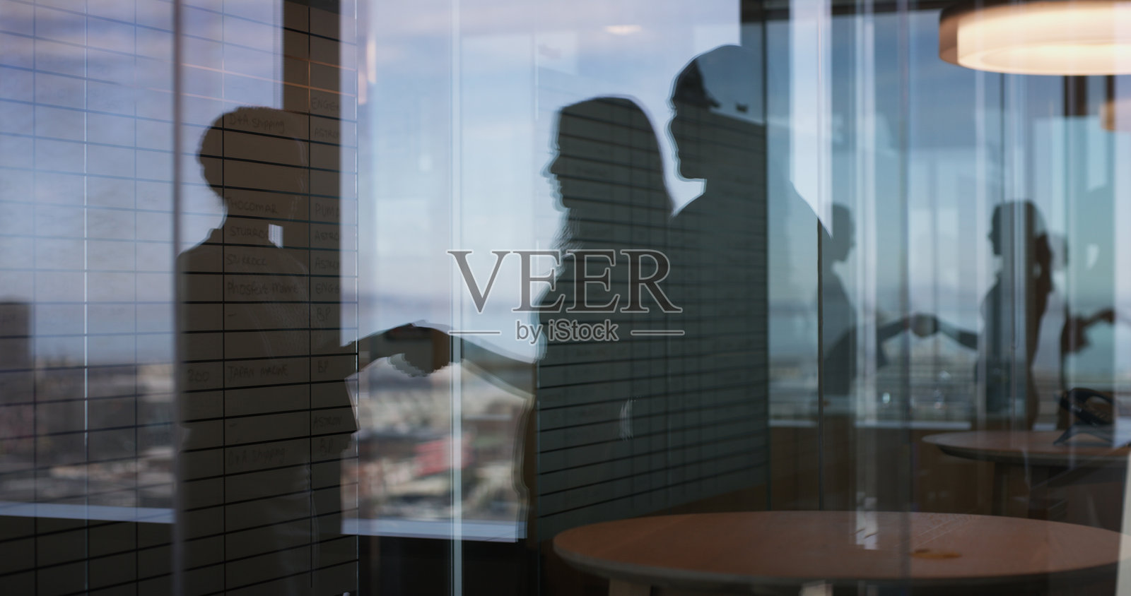 商务人士在办公室握手的剪影，庆祝晋升的成功与祝贺。团队、群体与感激的握手，在人力资源机构的窗边进行交易与反思。照片摄影图片