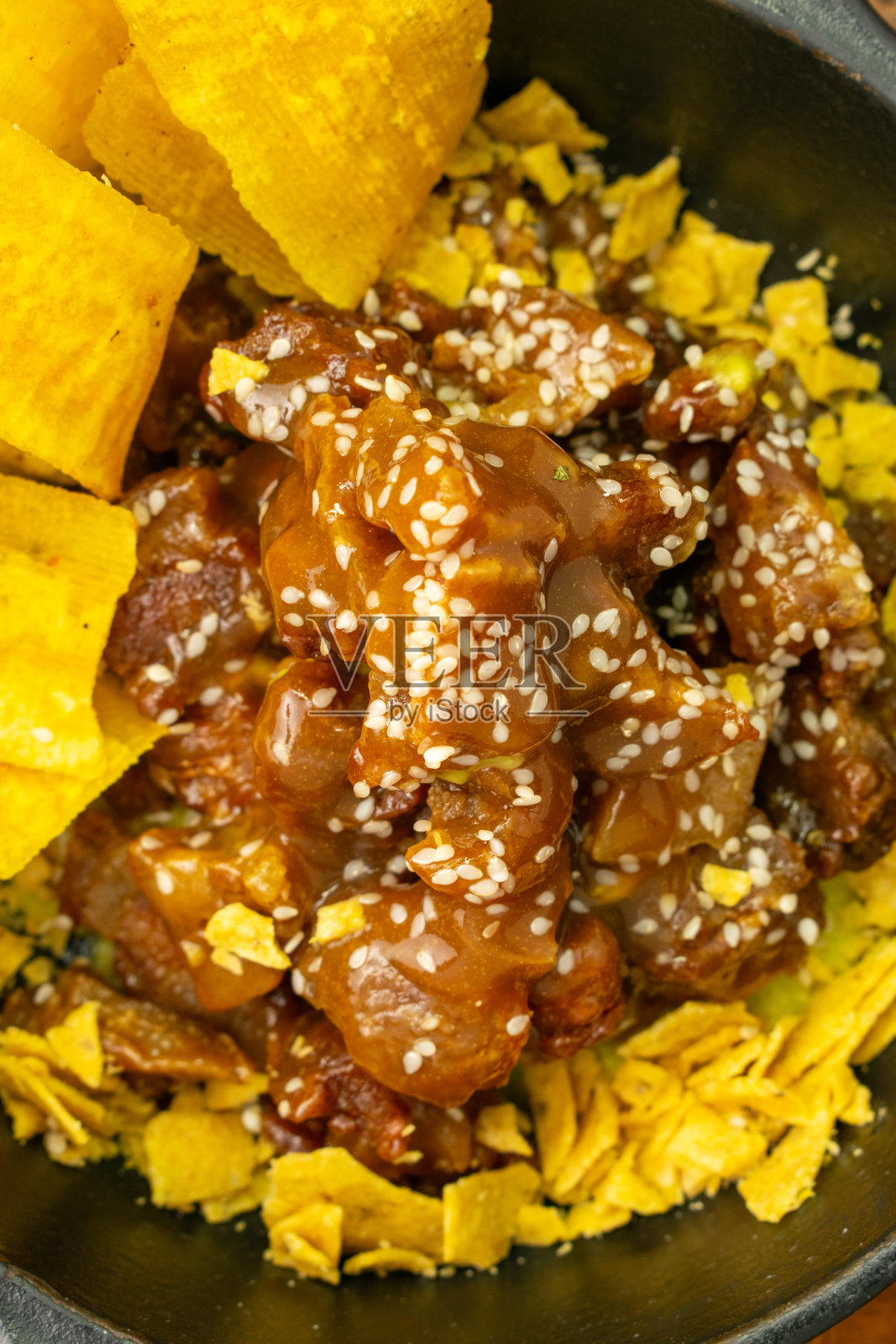 粘性猪肉块配青香蕉薯片和煎锅玉米饼碎照片摄影图片