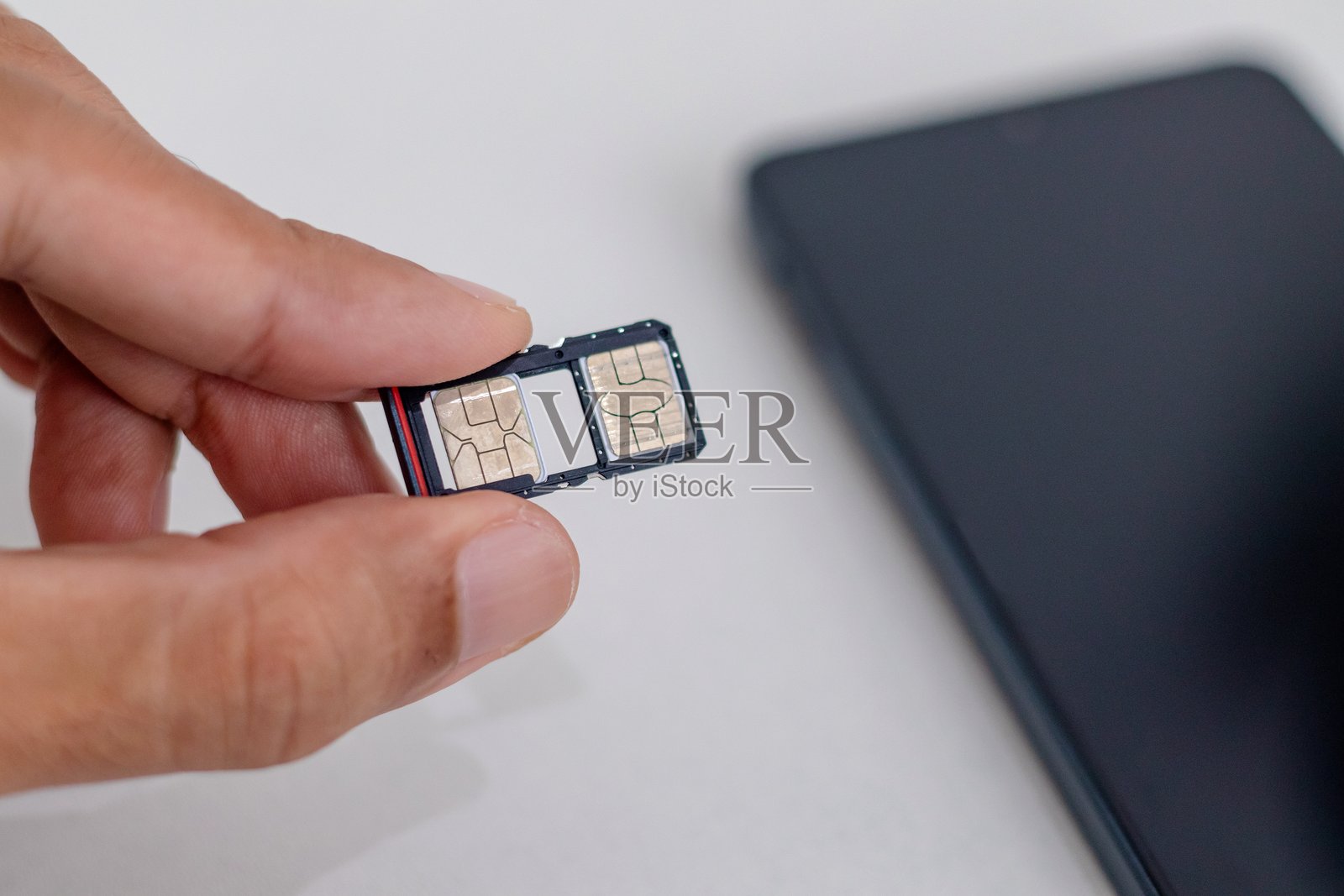 手握着智能手机的SIM卡槽打开部分照片摄影图片