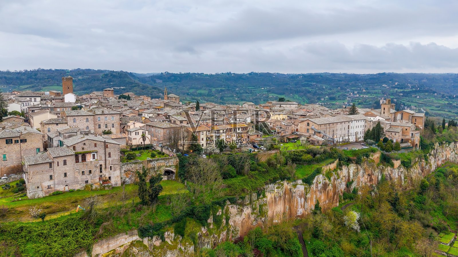 意大利翁布里亚地区的中世纪小镇奥尔维耶托的鸟瞰图，展示了标志性的钟楼、奥尔维耶托大教堂和历史悠久的石建筑，云层密布，古老的建筑风格和旅游推广的旅行概念。照片摄影图片