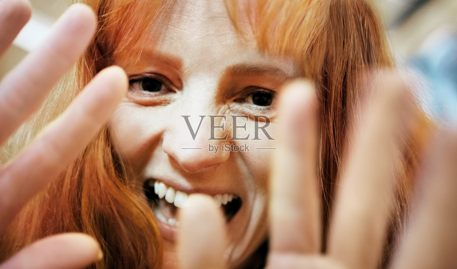 红发女性特写视角，做出搞笑表情并微笑照片摄影图片