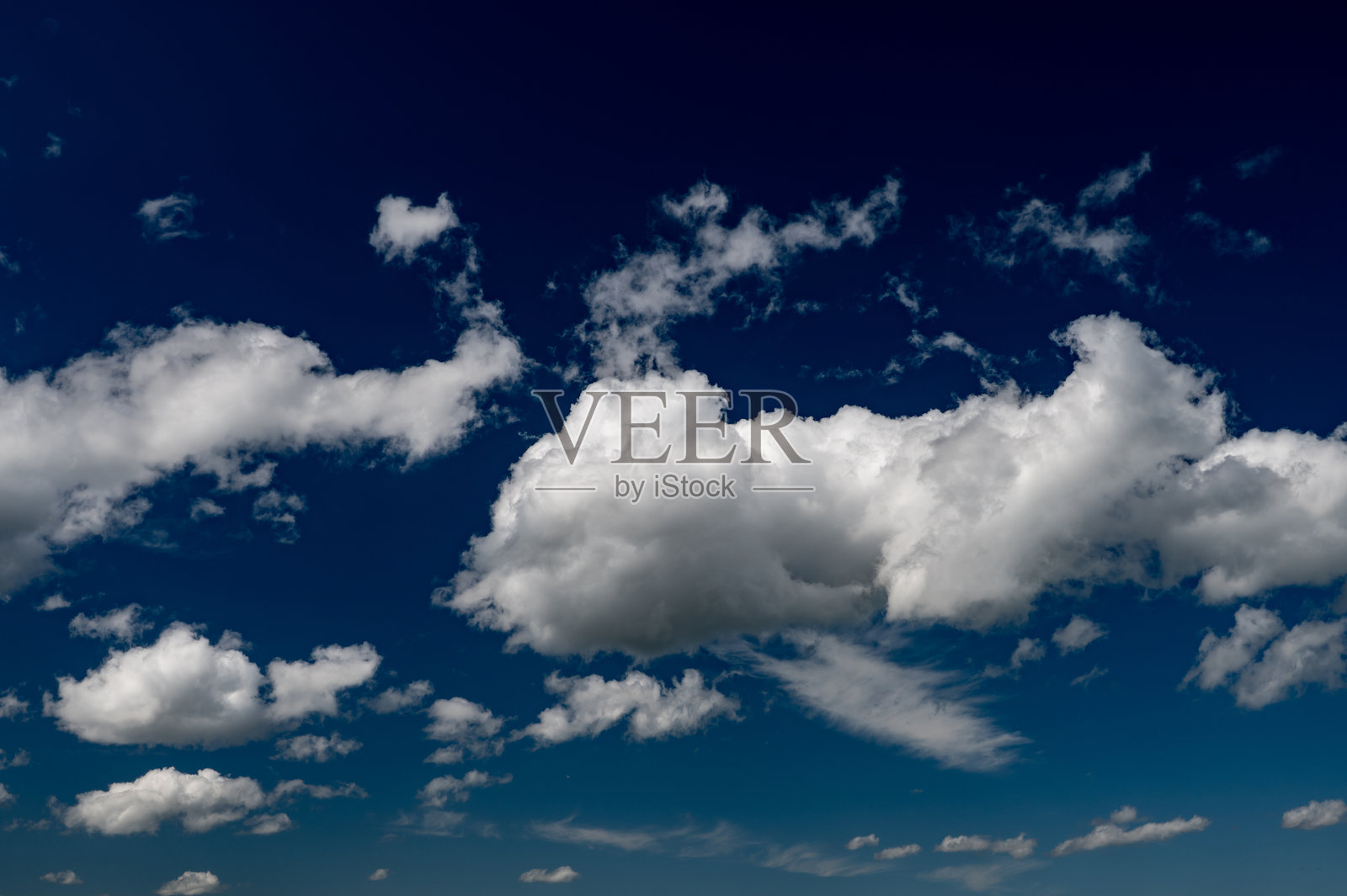 蓬松的云朵在深蓝色的天空中漂浮照片摄影图片