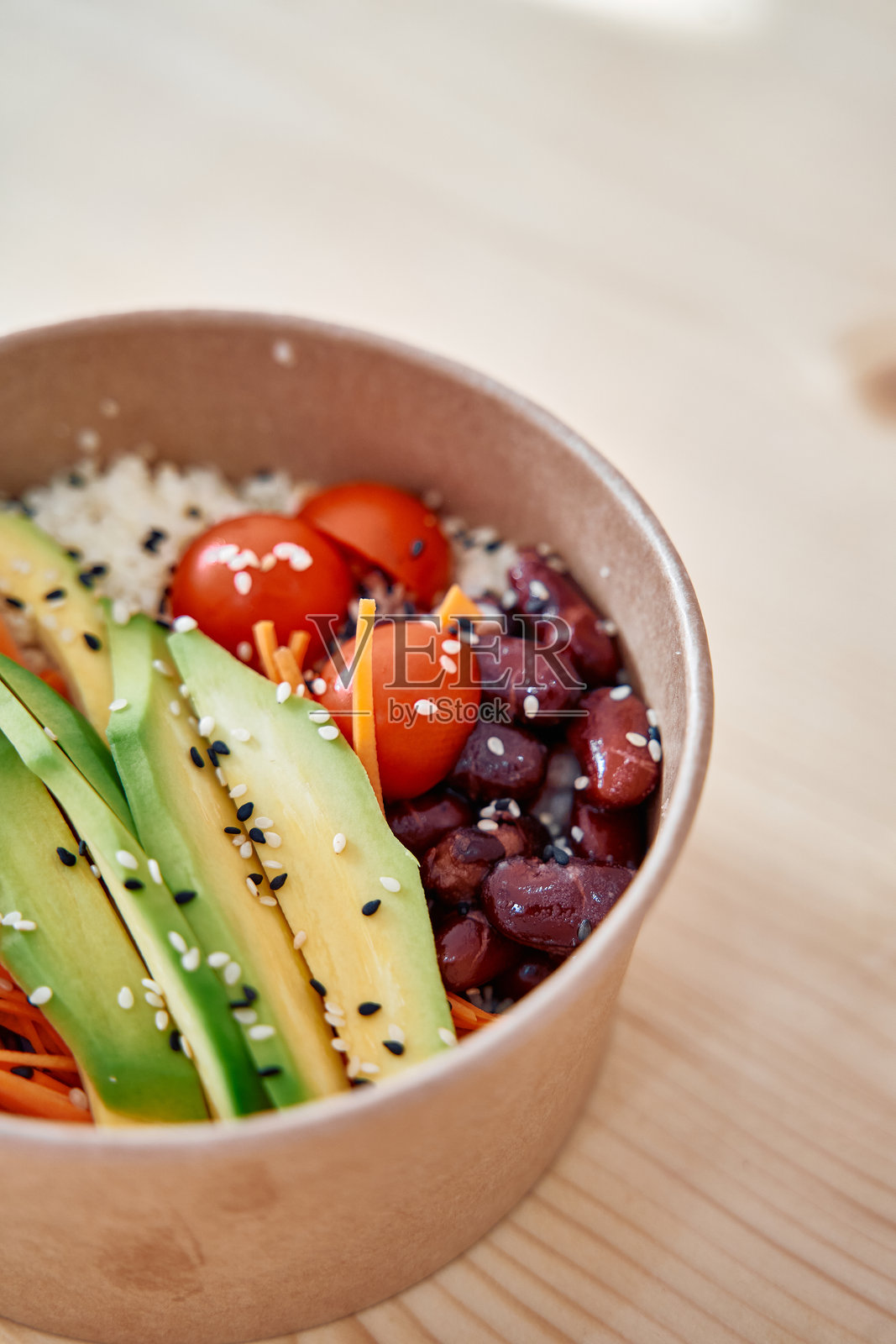 新鲜鳄梨和豆类沙拉碗，配有番茄和芝麻，放在浅色木质表面上照片摄影图片