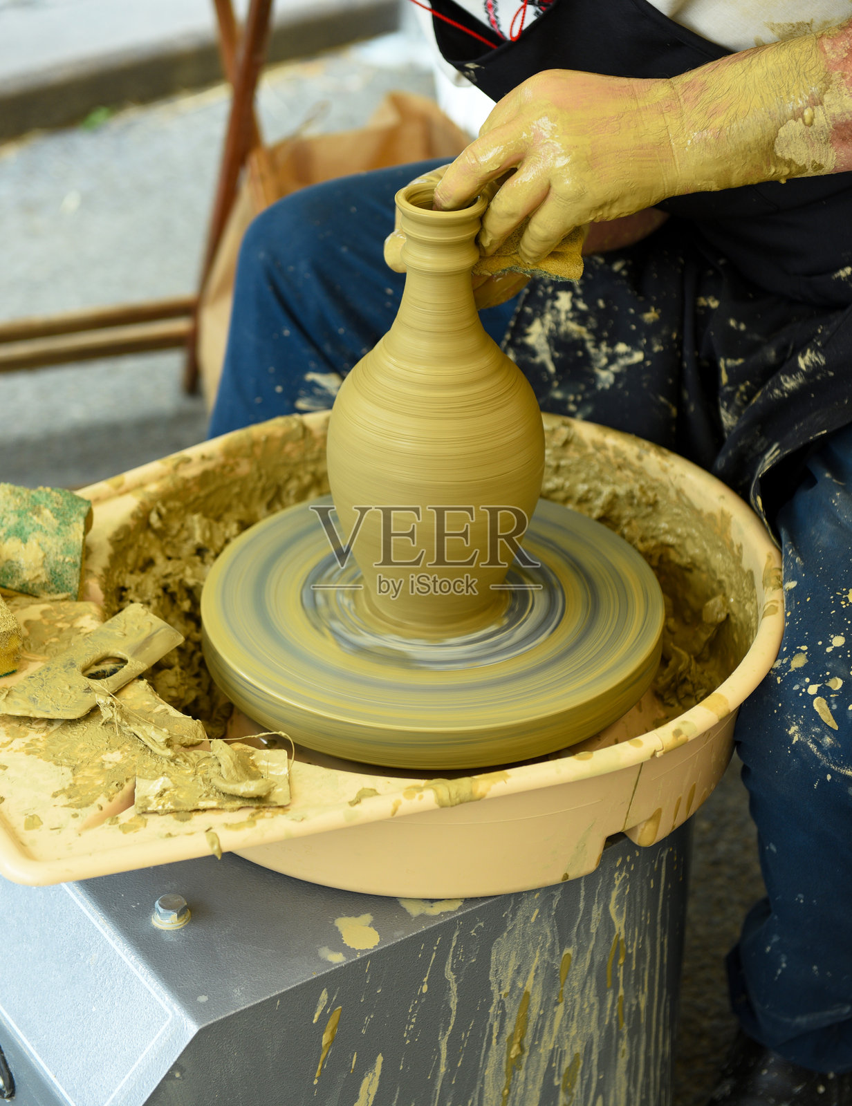 陶艺节上，陶工的双手在陶轮上塑造陶罐照片摄影图片