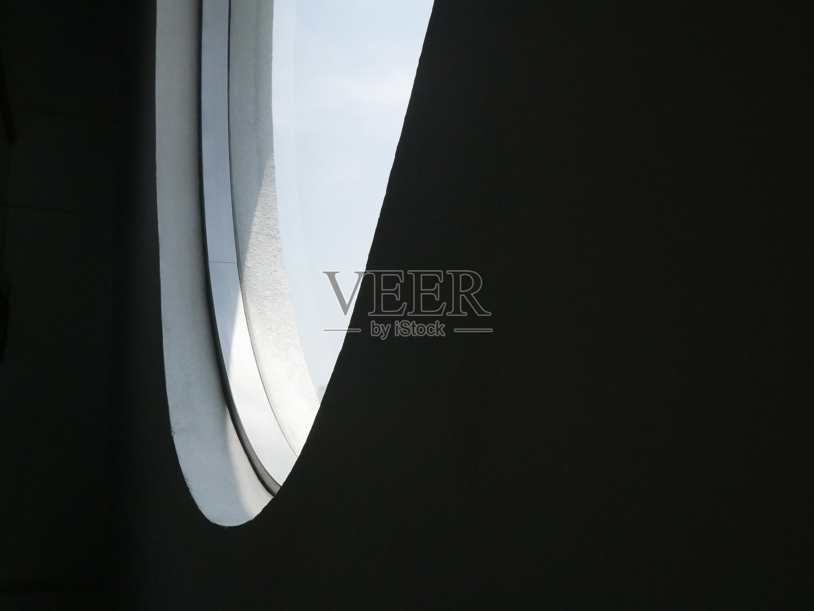 现代建筑室内的圆形天窗视图，将光线投射到下面的空间。照片摄影图片