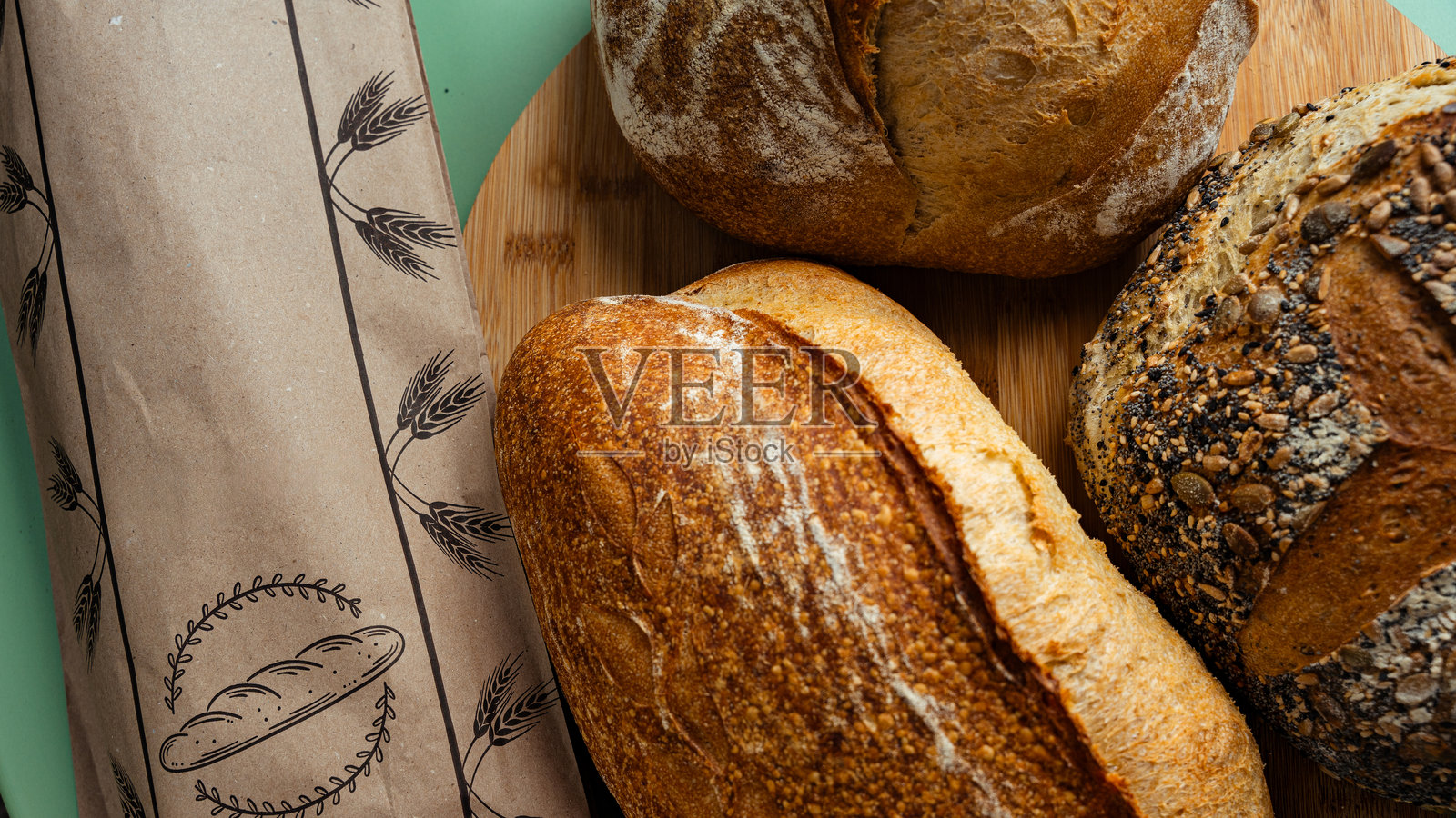 新鲜出炉的面包放在木板和纸袋上休息照片摄影图片