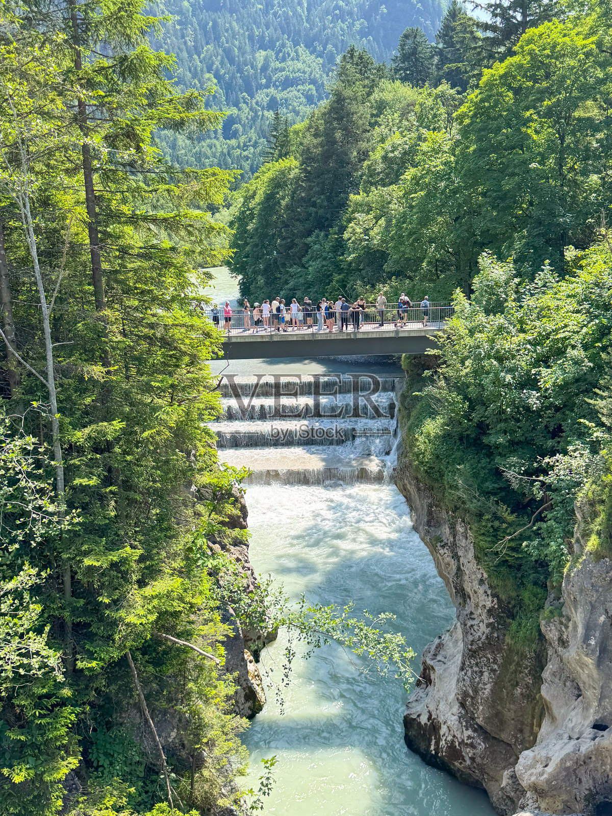 游客在桥上的观景点欣赏风景如画的瀑布照片摄影图片