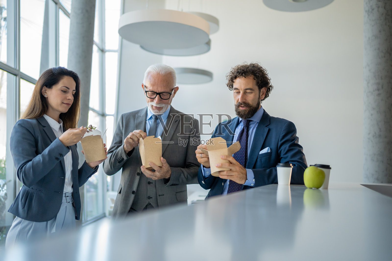 商务人士在午餐时间在办公室吃外卖食物照片摄影图片