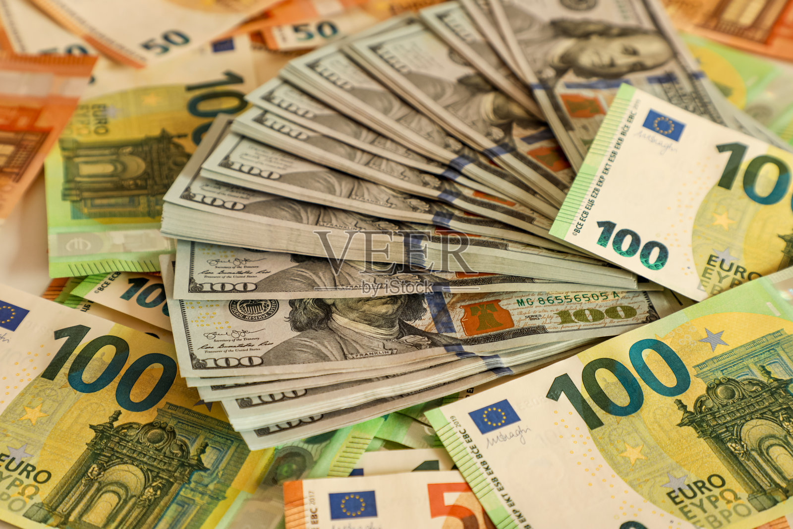 重叠的100美元和50欧元钞票的详细特写，完美捕捉财富、金融、全球经济和国际贸易的本质。照片摄影图片