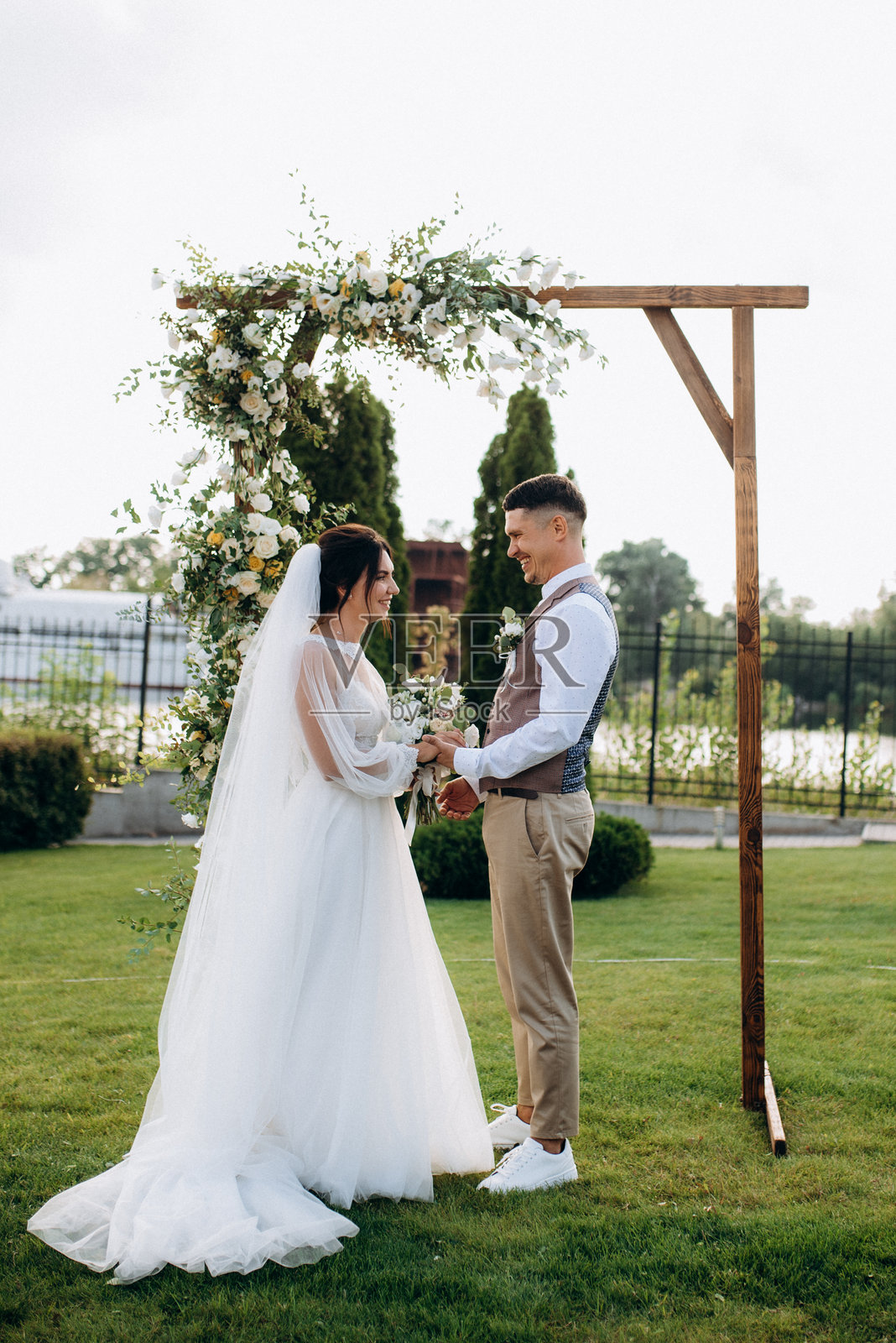 一对年轻情侣在绿色草地上的婚礼仪式照片摄影图片