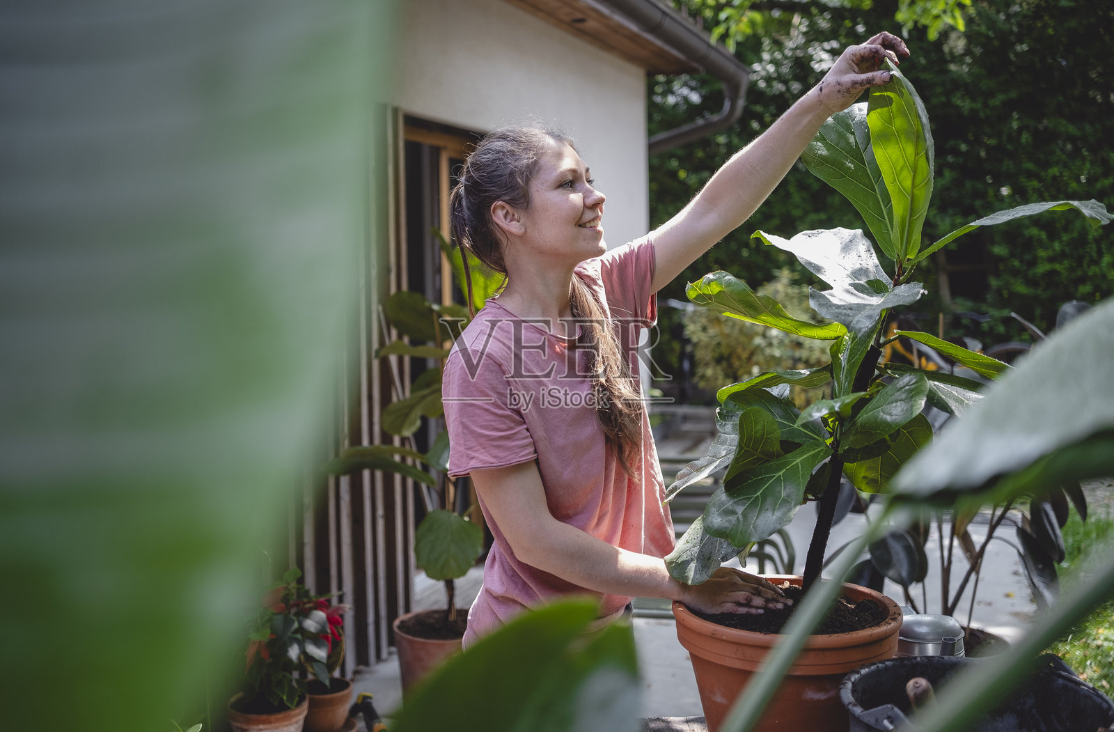 年轻女性在后院通过换盆种植享受园艺乐趣照片摄影图片