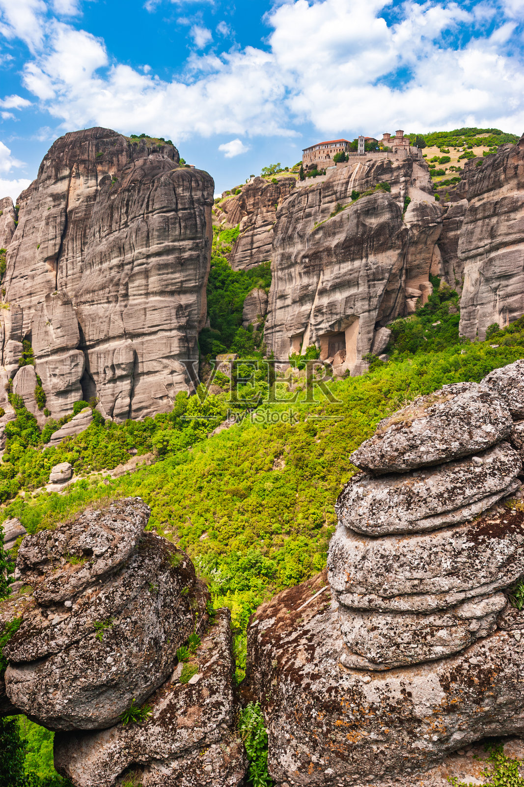 位于希腊梅泰奥拉的中世纪修道院，坐落在巨大的岩石上，俯瞰着郁郁葱葱的山谷。照片摄影图片