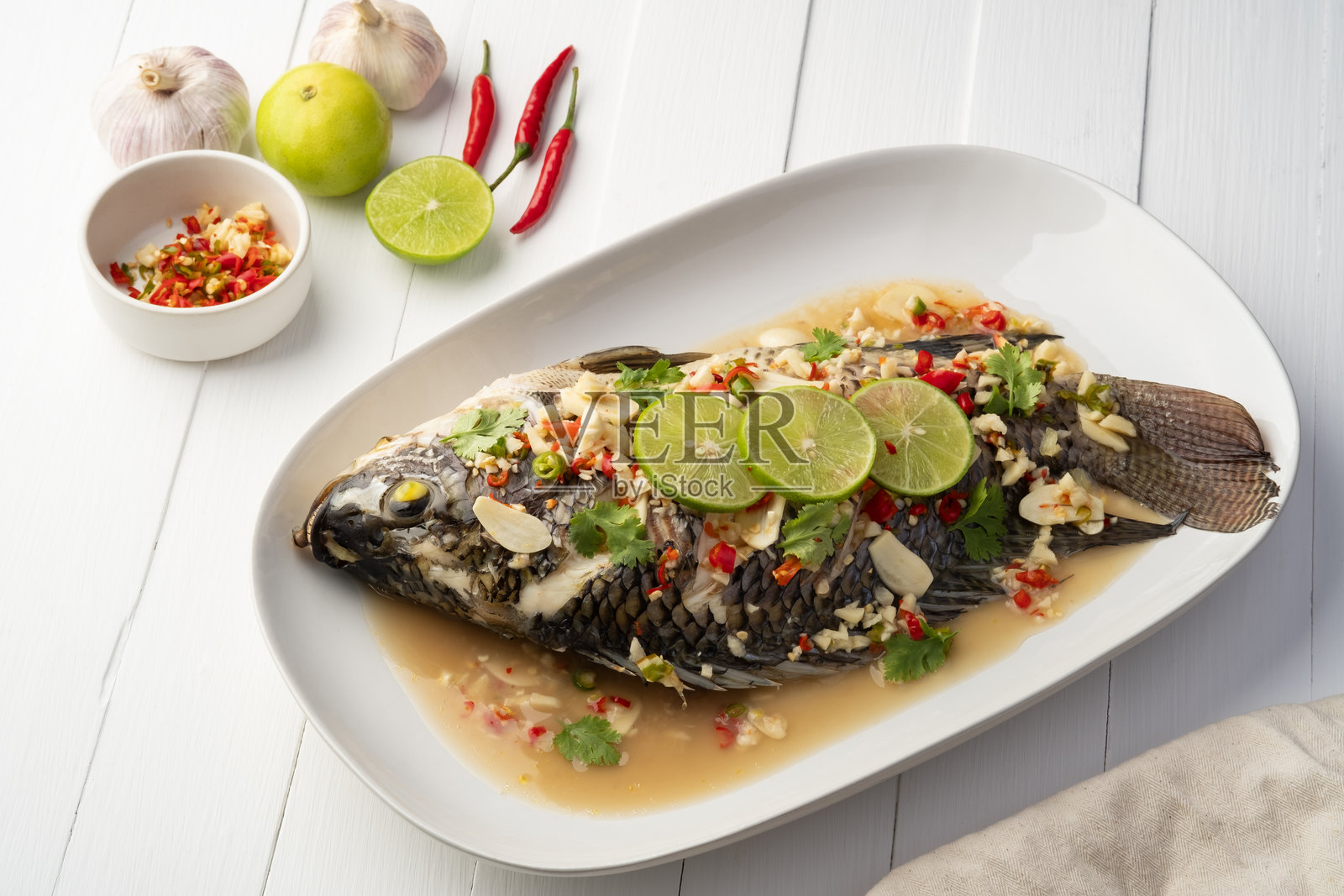 香辣青柠汤蒸罗非鱼。照片摄影图片