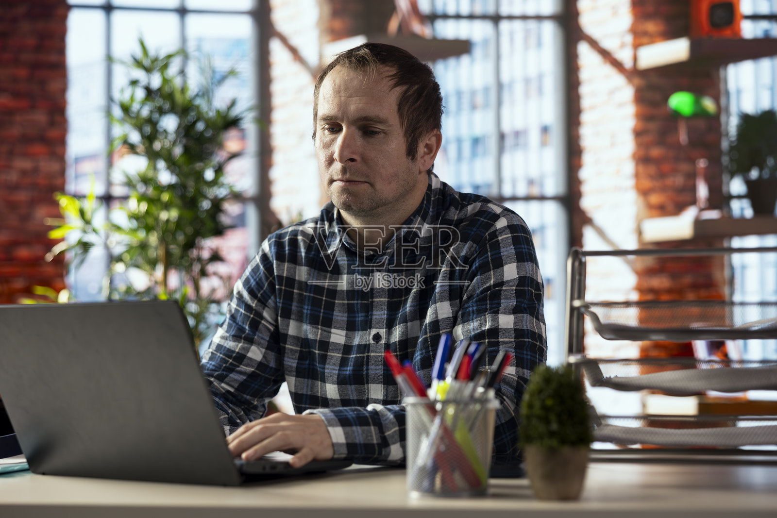 员工在工作站上使用笔记本电脑完成电子表格照片摄影图片