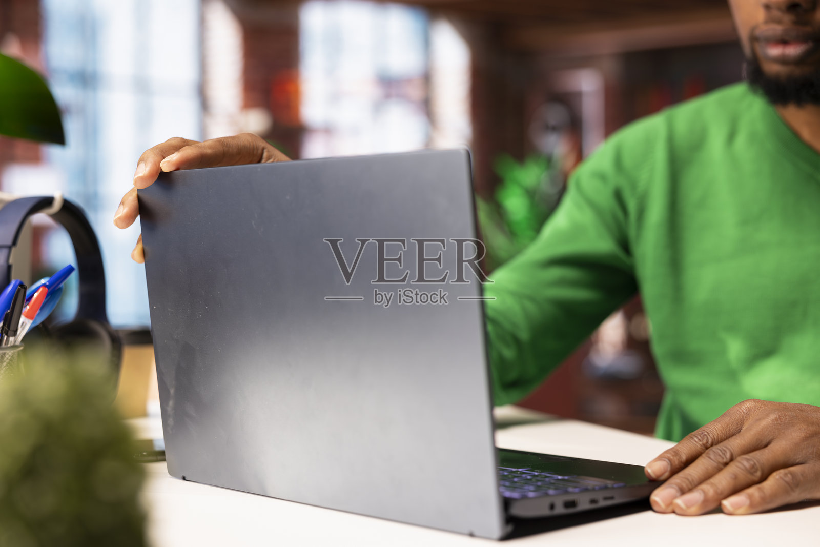 在家办公室的桌子旁坐着的自由职业者，使用笔记本电脑，特写镜头照片摄影图片