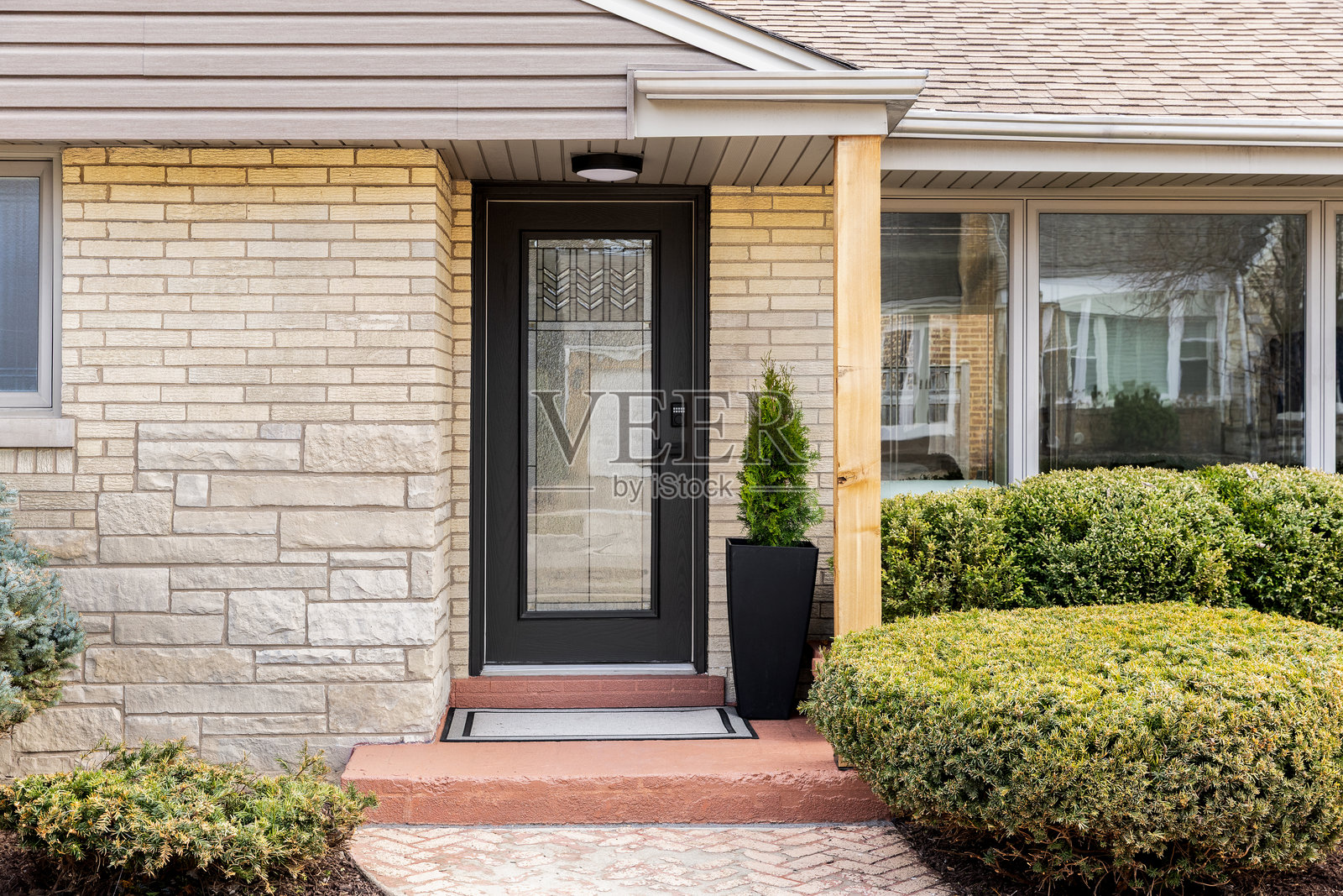 黑色前门细节，配有砖石外墙。照片摄影图片