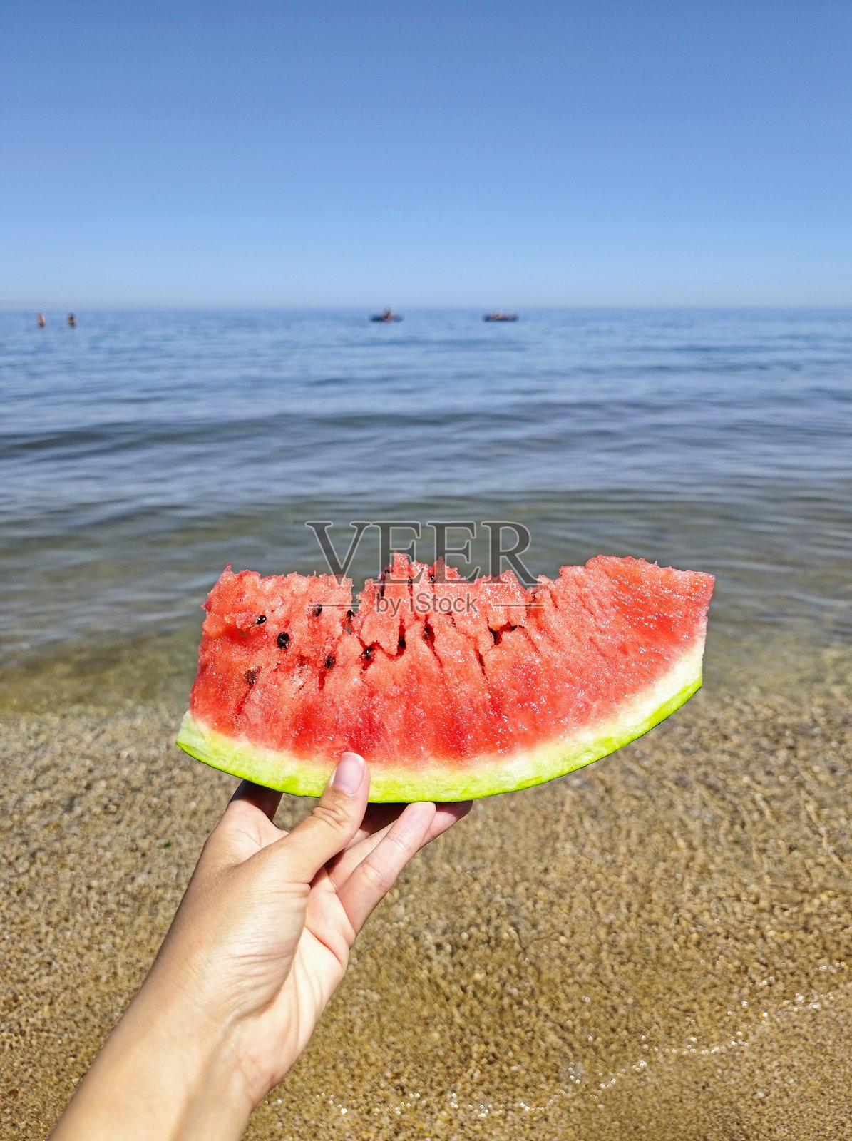 女人在海滩上手持西瓜照片摄影图片